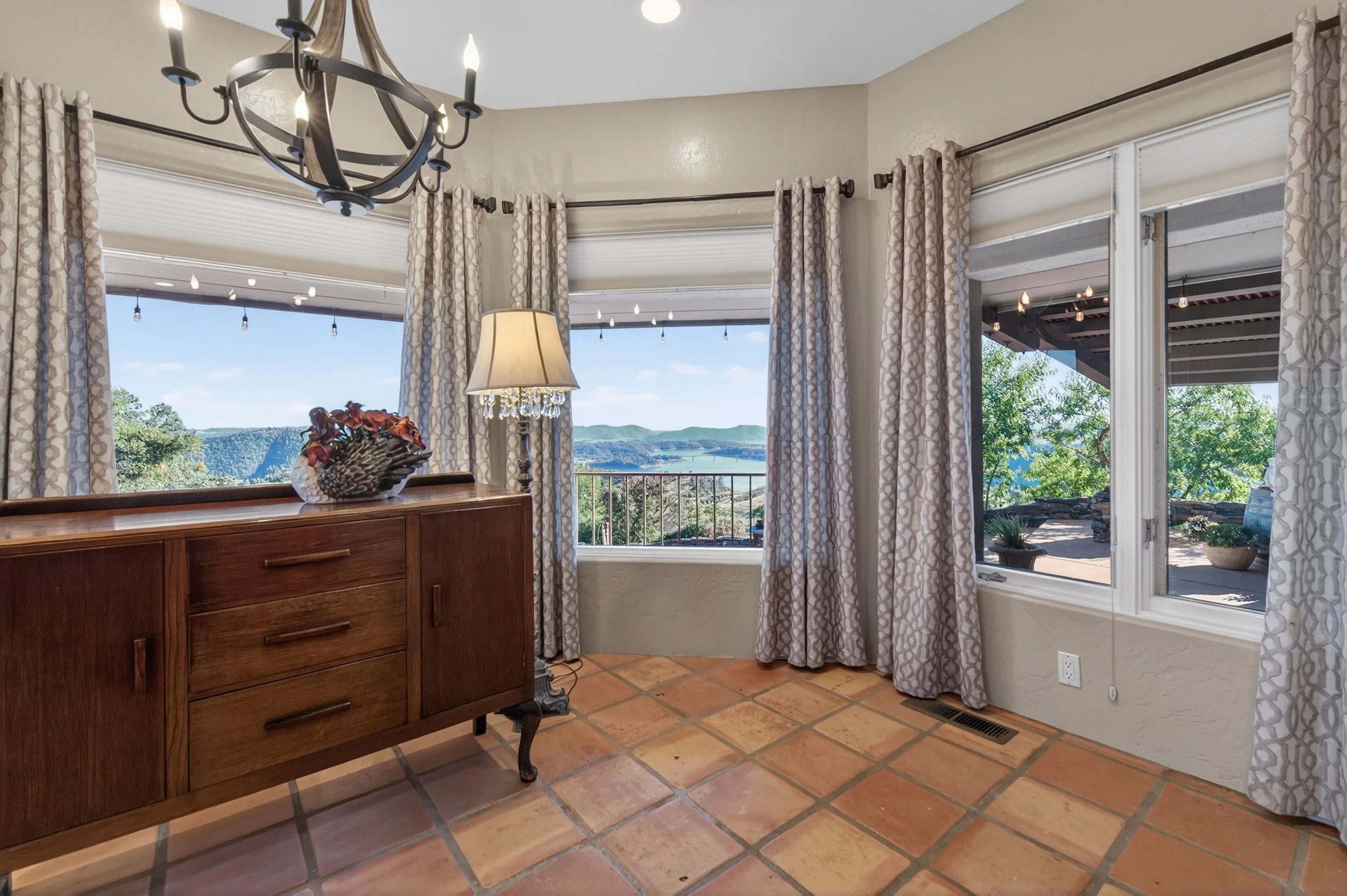 Family room at Airola Ranch in Vallecito California featuring panoramic views of New Melones Lake, expansive picture windows, and elegant Sierra Foothill living