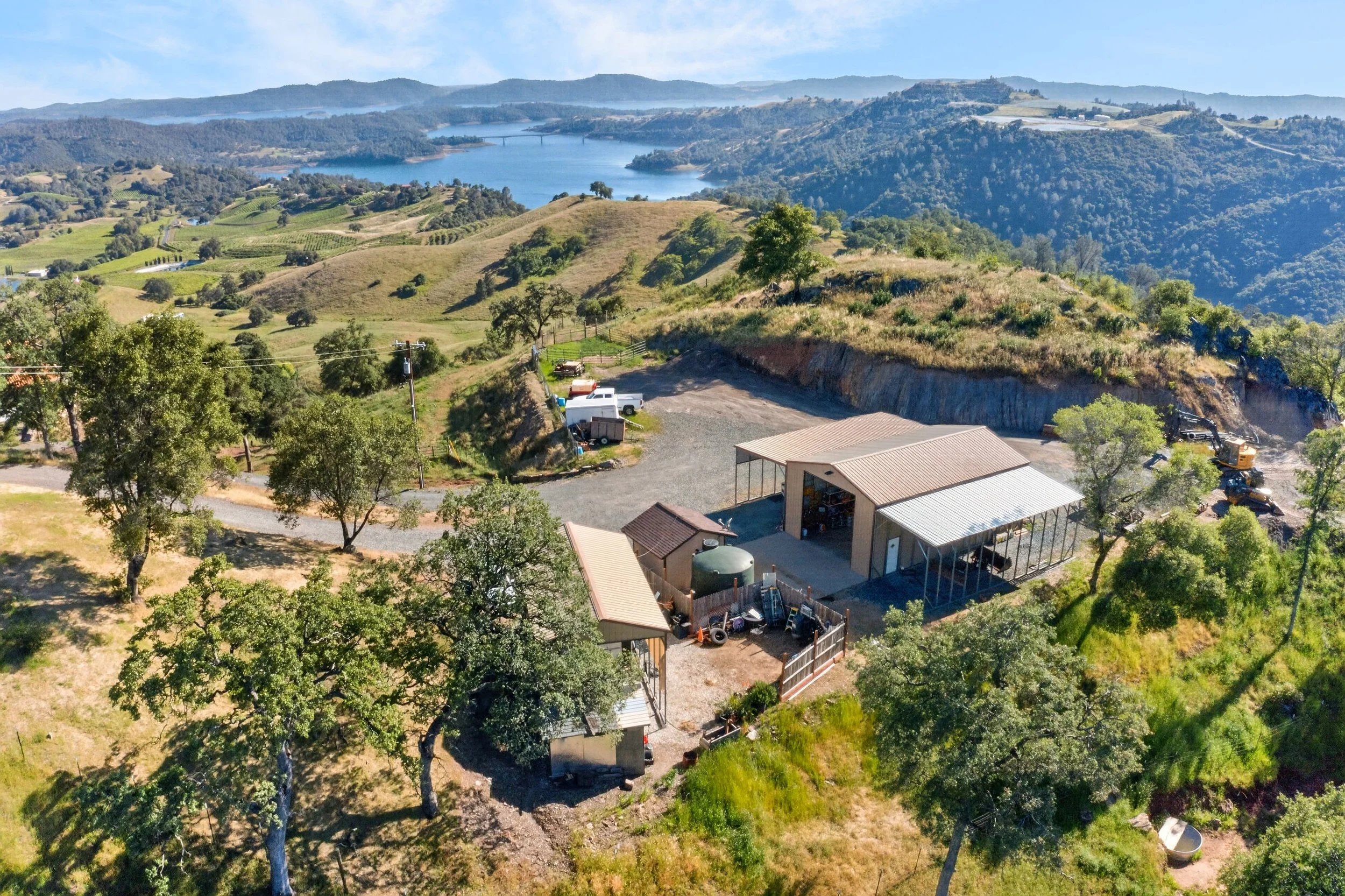 Aerial view of Airola Ranch in Vallecito California featuring rolling foothills, lake views, ranch infrastructure, and scenic Calaveras County landscapes