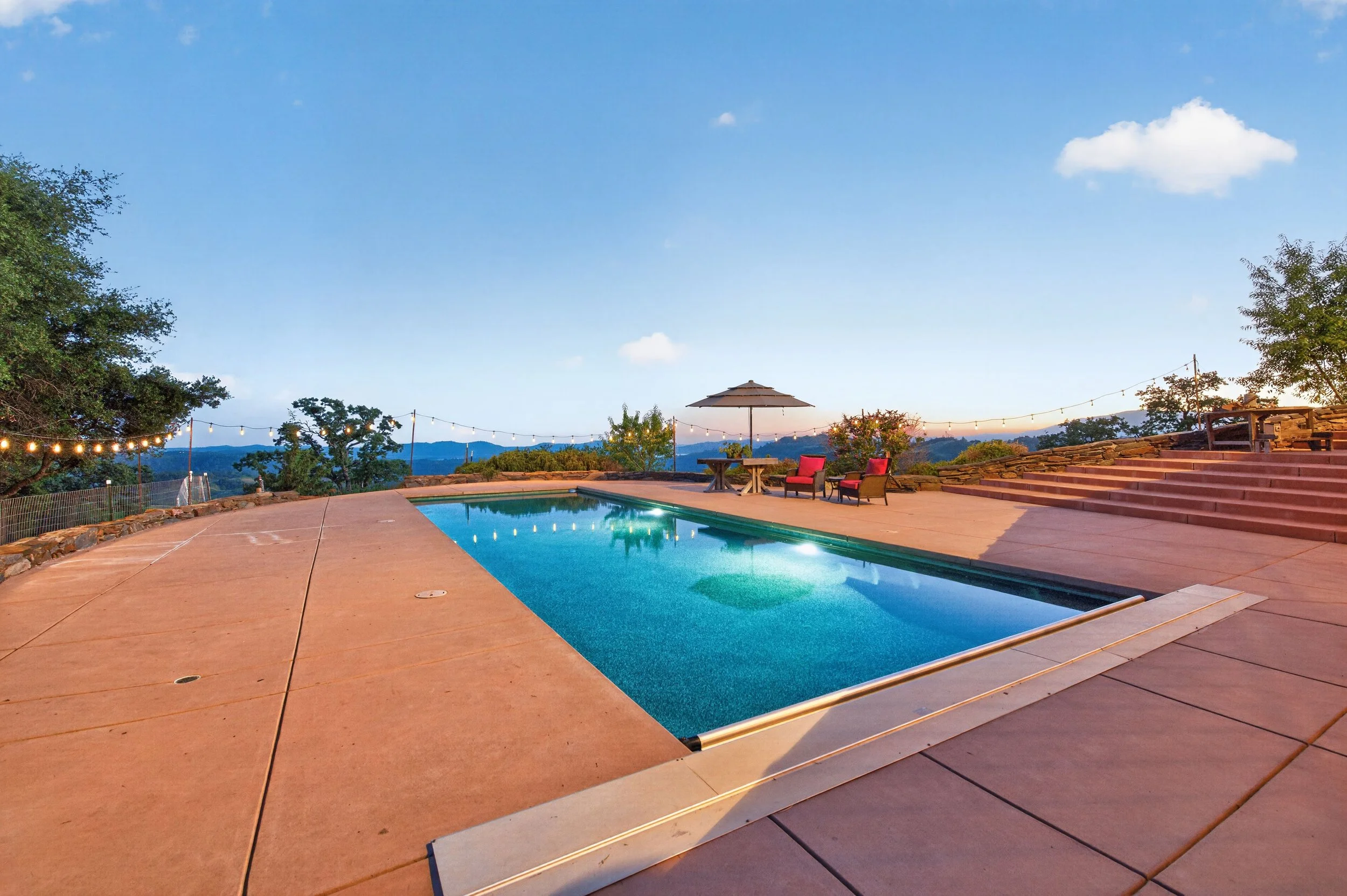 Private estate pool area in Vallecito California featuring expansive outdoor seating and elevated lake views.