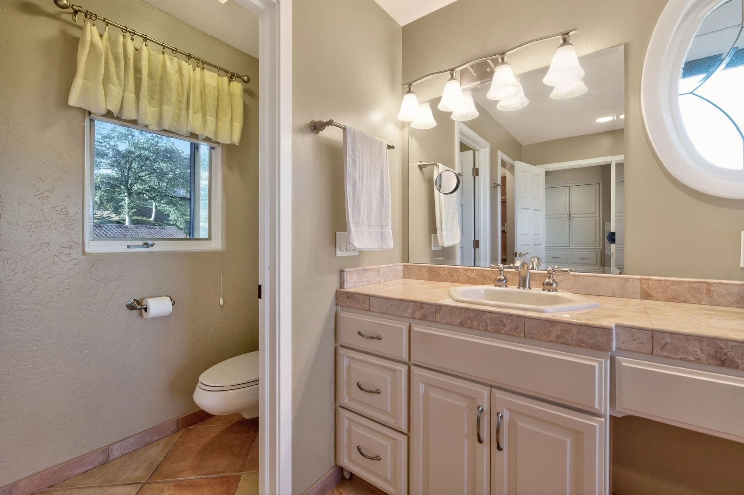 Spacious bathroom in Vallecito California estate home featuring tile flooring, custom cabinetry, and natural window light.