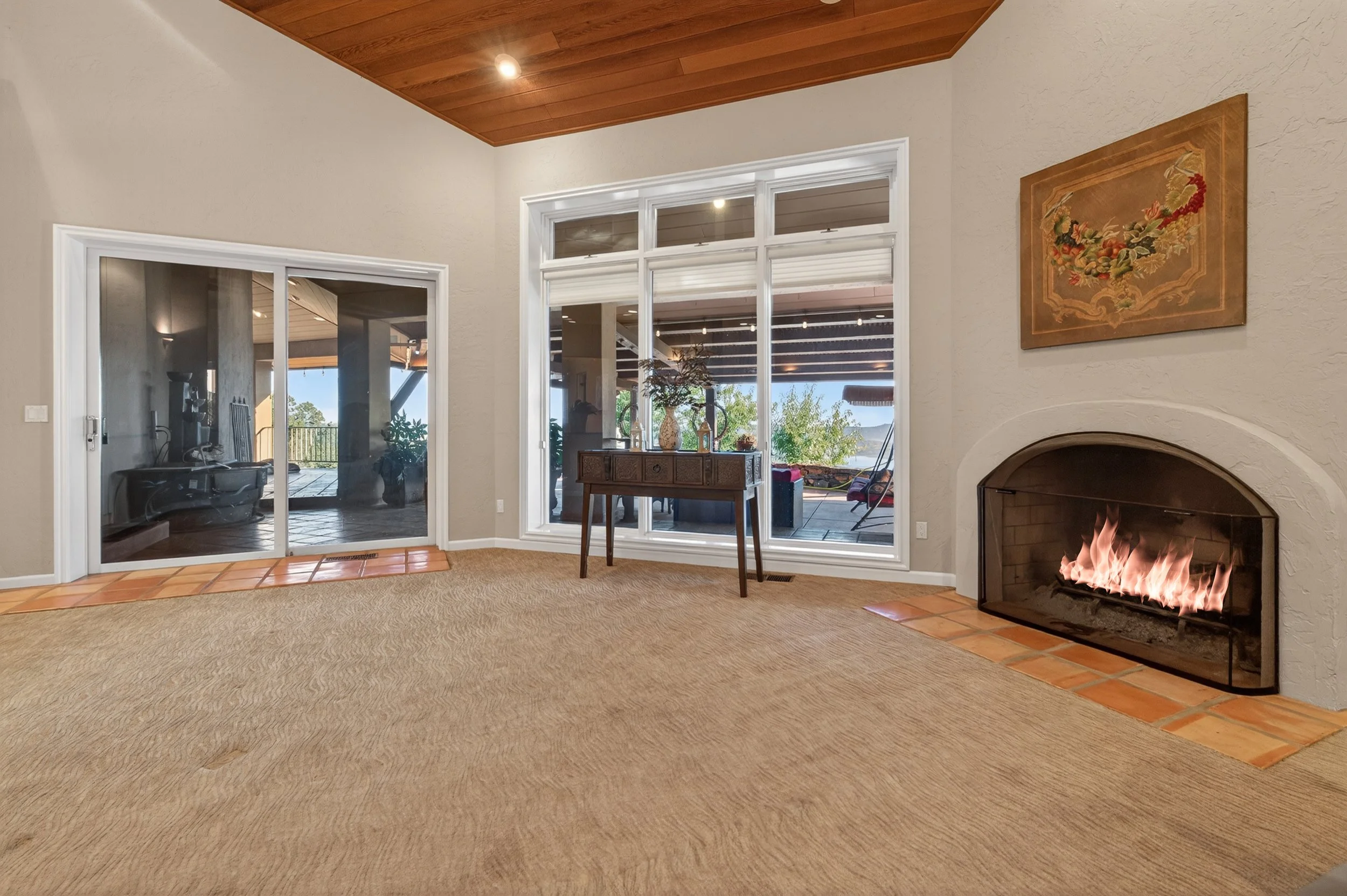 Luxury living room at Airola Ranch in Vallecito California featuring vaulted wood ceilings, fireplace, and panoramic Sierra Foothill views and panoramic view of New Melones Lake.