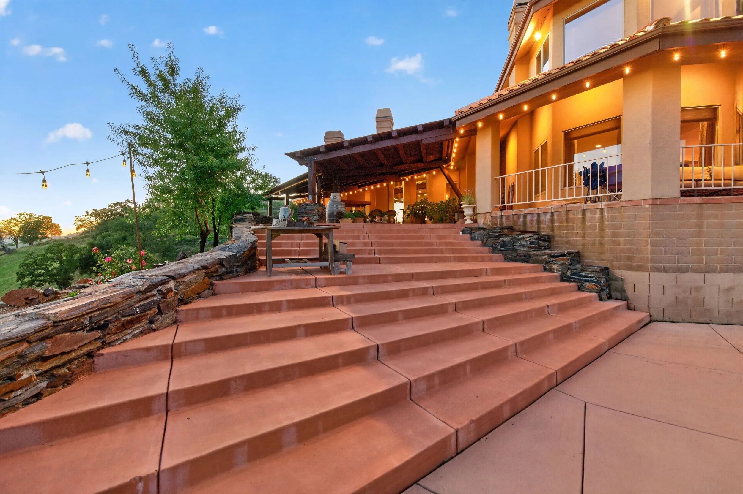Welcoming front porch entry at Airola Cattle Ranch in Vallecito California featuring terracotta steps, outdoor ambiance lighting, and elegant Sierra Foothill estate design.