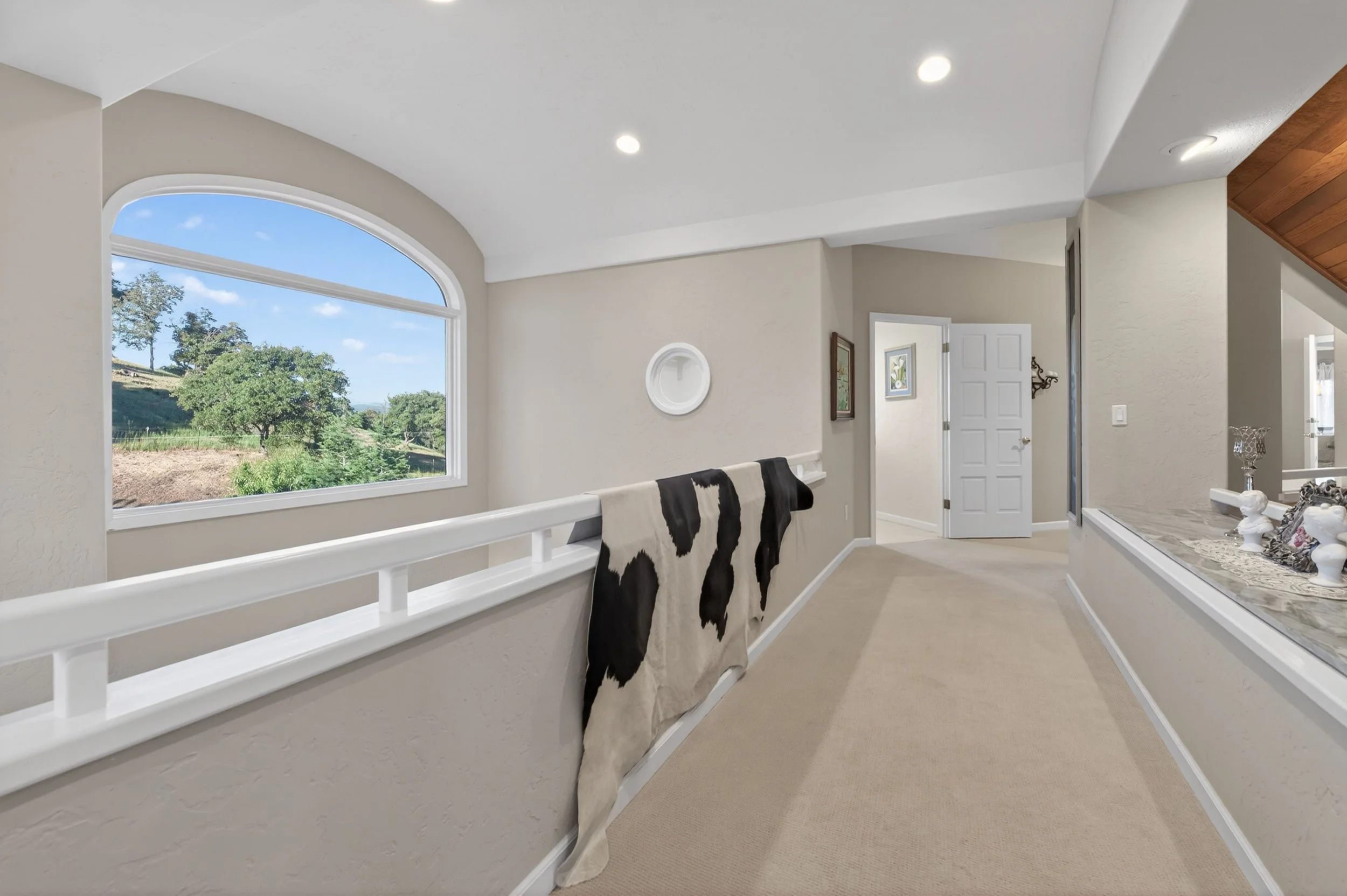 Interior living space at Airola Ranch in Vallecito California featuring dramatic arched windows, natural light, and panoramic Sierra Foothill views