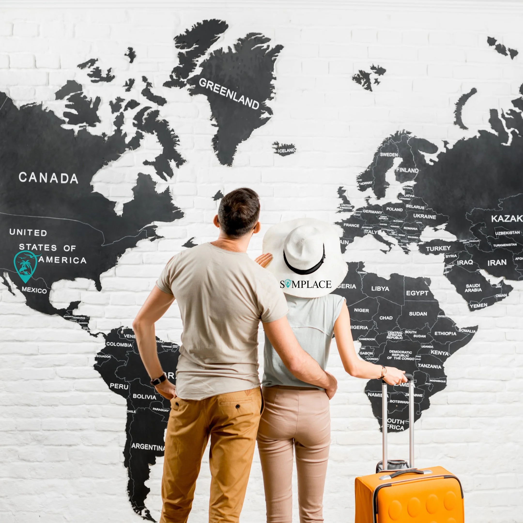 Dos personas con sombreros de viaje están mirando un mapa mural del mundo en una pared de ladrillos blancos, que destaca países como Groenlandia, Canadá, Estados Unidos y países europeos.