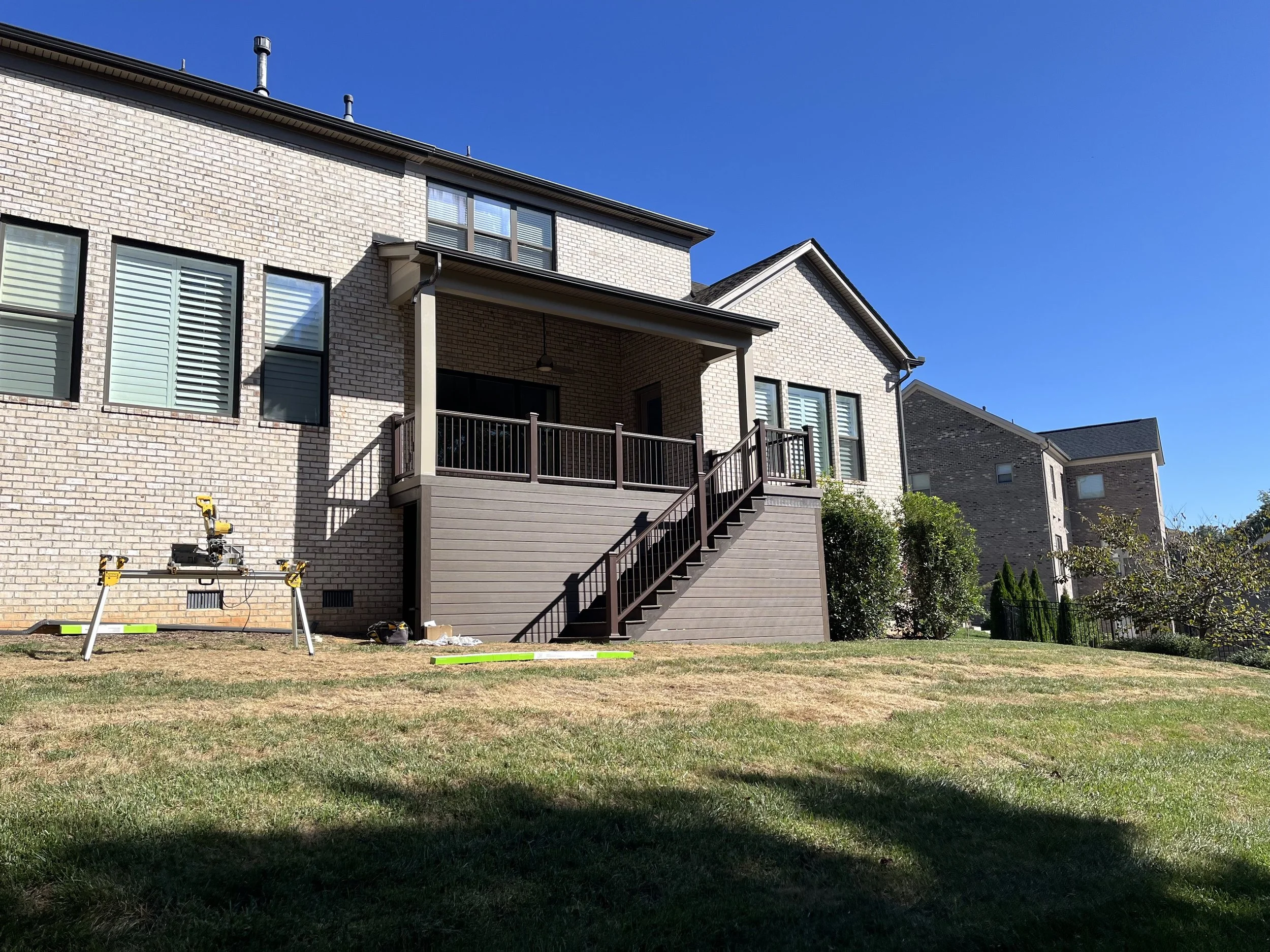 Composite deck with staircase and handrails and an under-deck wall built by McGuirt Carpentry & Construction