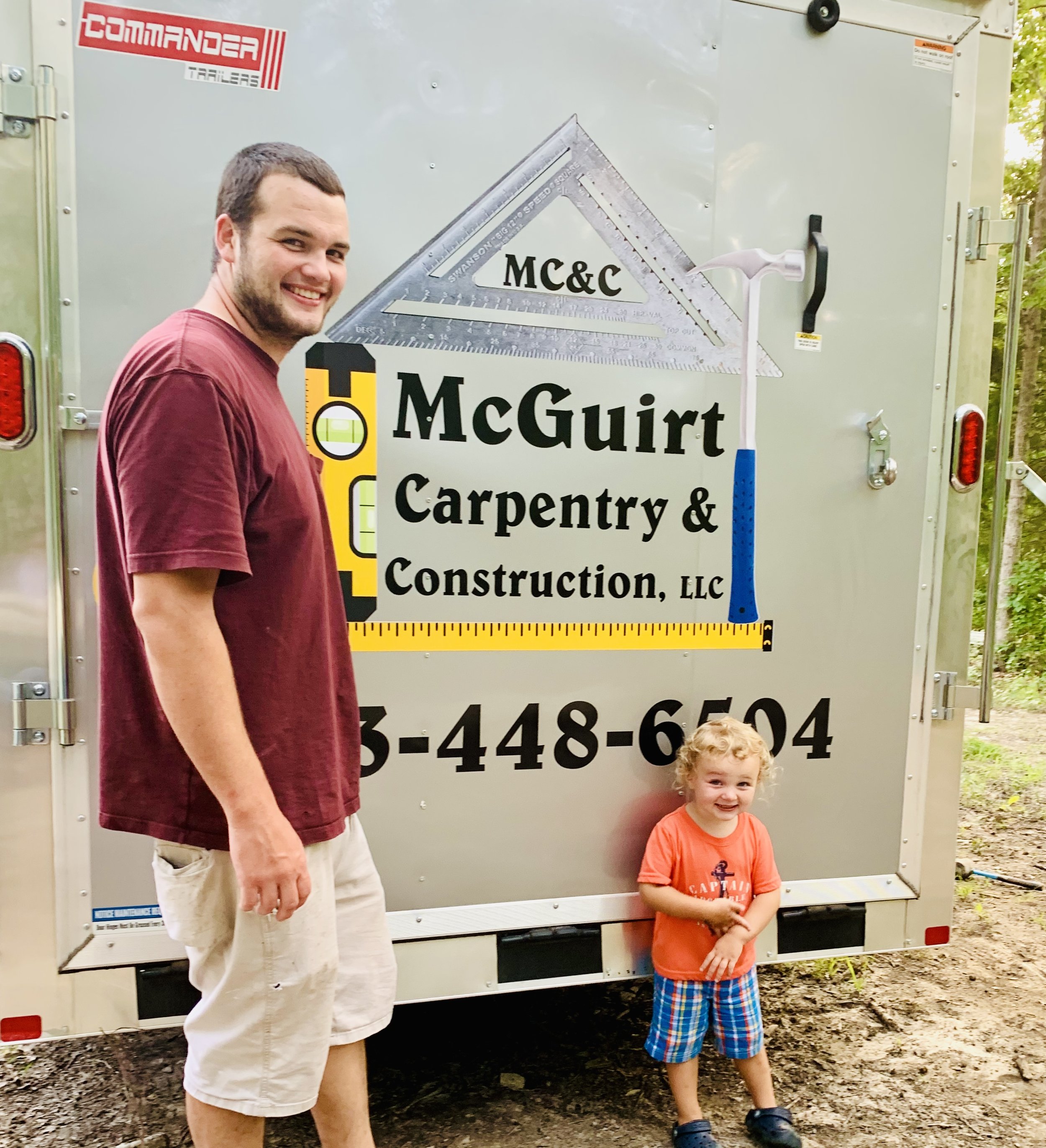 Randall McGuirt with his son Braxton beside the company's first trailer.