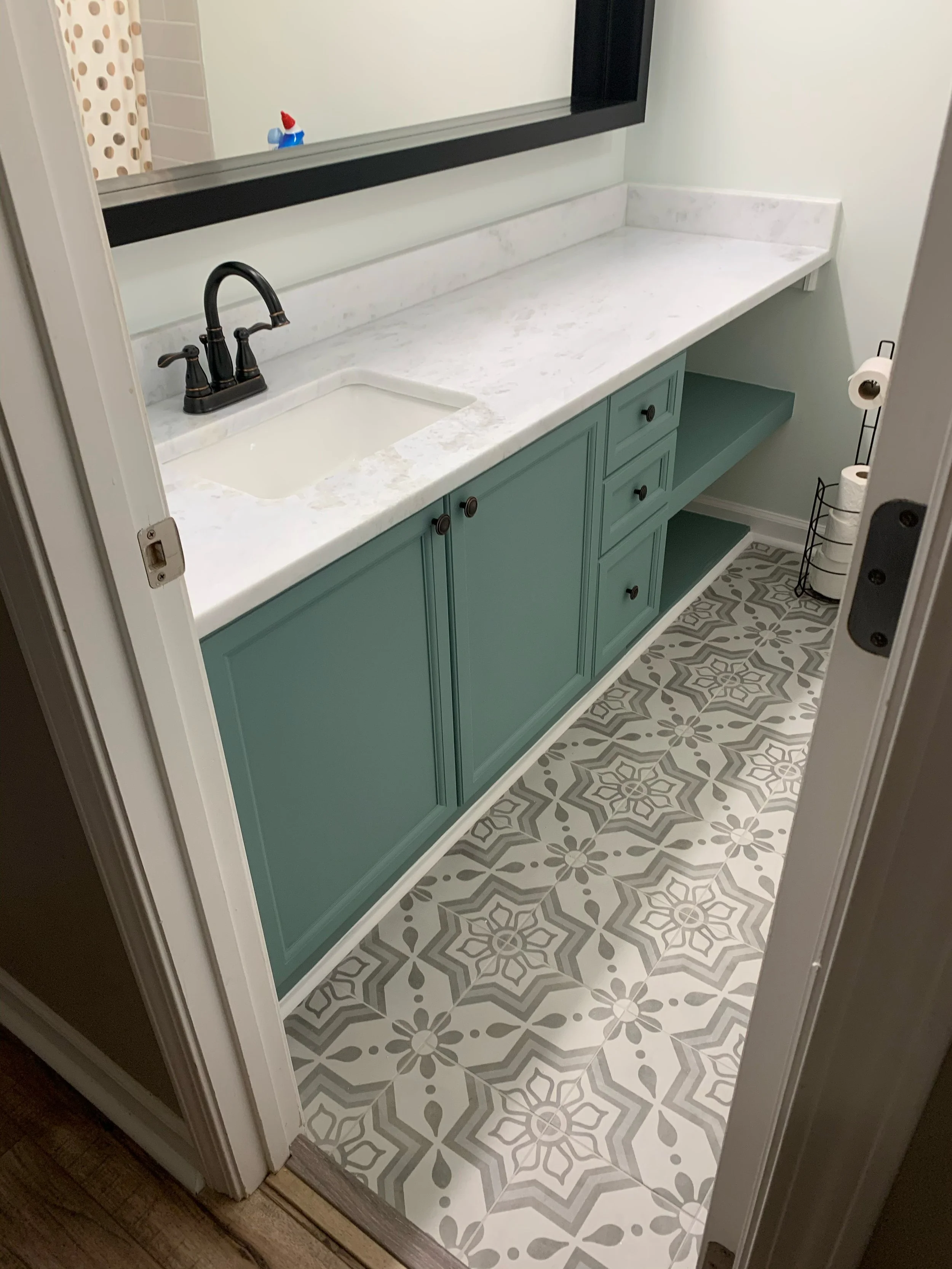 Custom bathroom vanity with painted cabinetry, quartz countertop, undermount sink, and patterned tile flooring in Lancaster, SC.