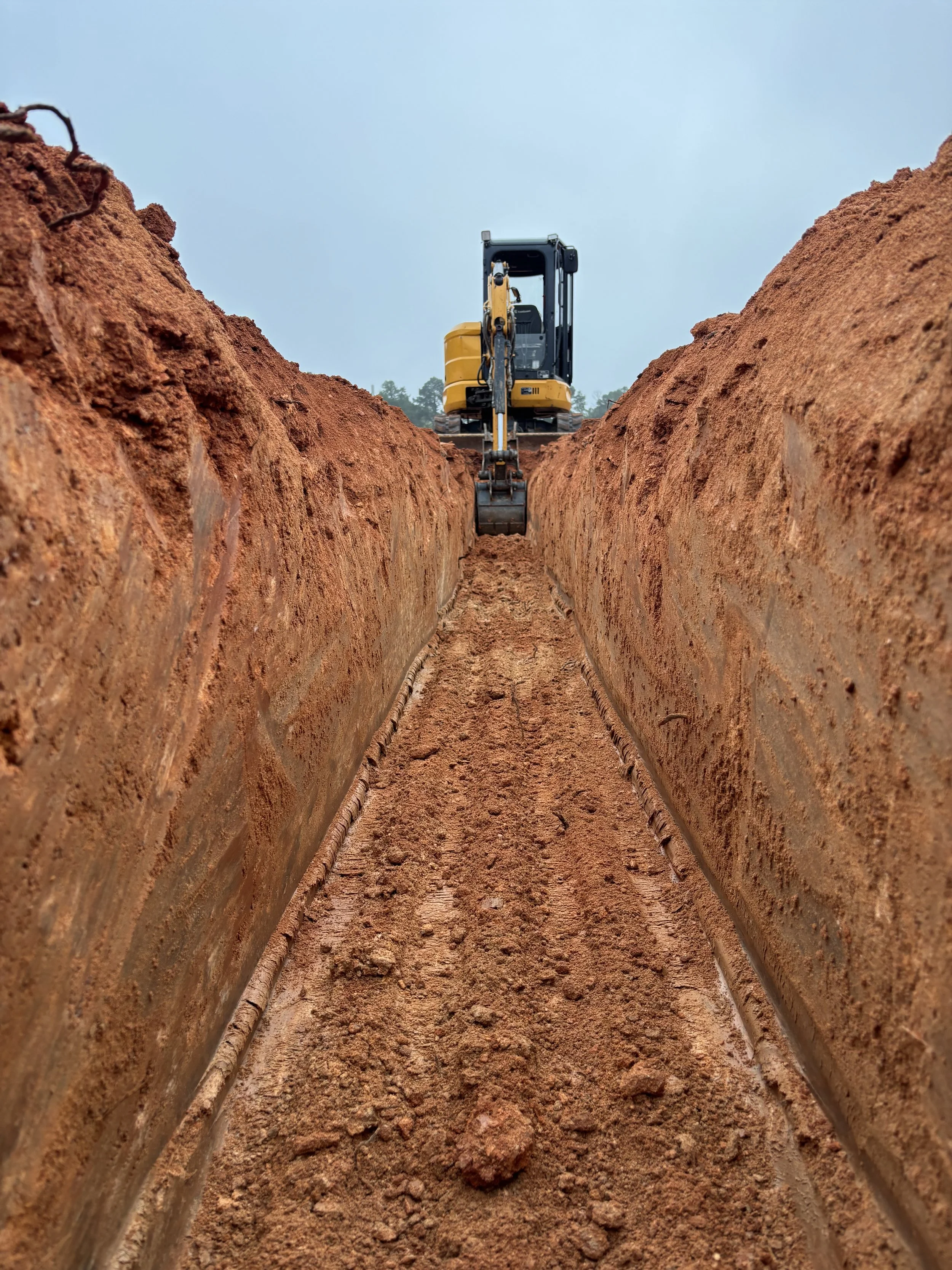 Mini excavator digging a trench during a residential excavation project