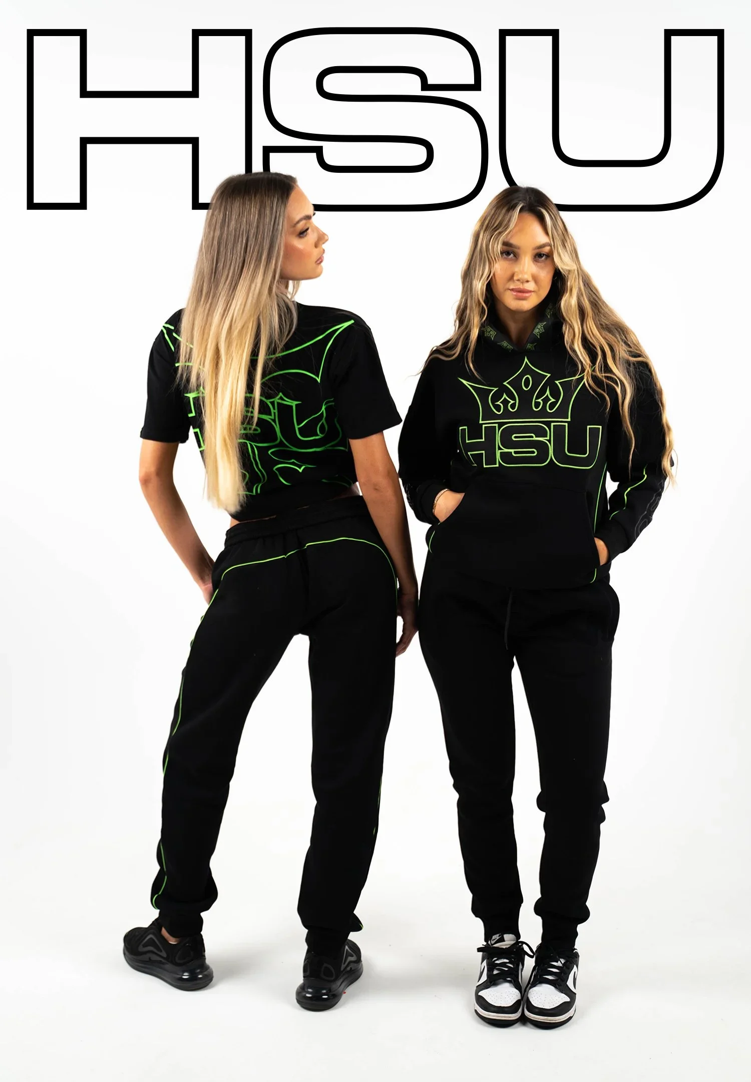 Two young women wear black streetwear with neon green outlines and 'HSU' logos, standing against a white background, with large 'HSU' text above them.