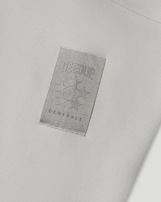 Close-up of a white fabric with a gray geedsup logo patch that has stars and the text 'GEEUP GENUINE'.