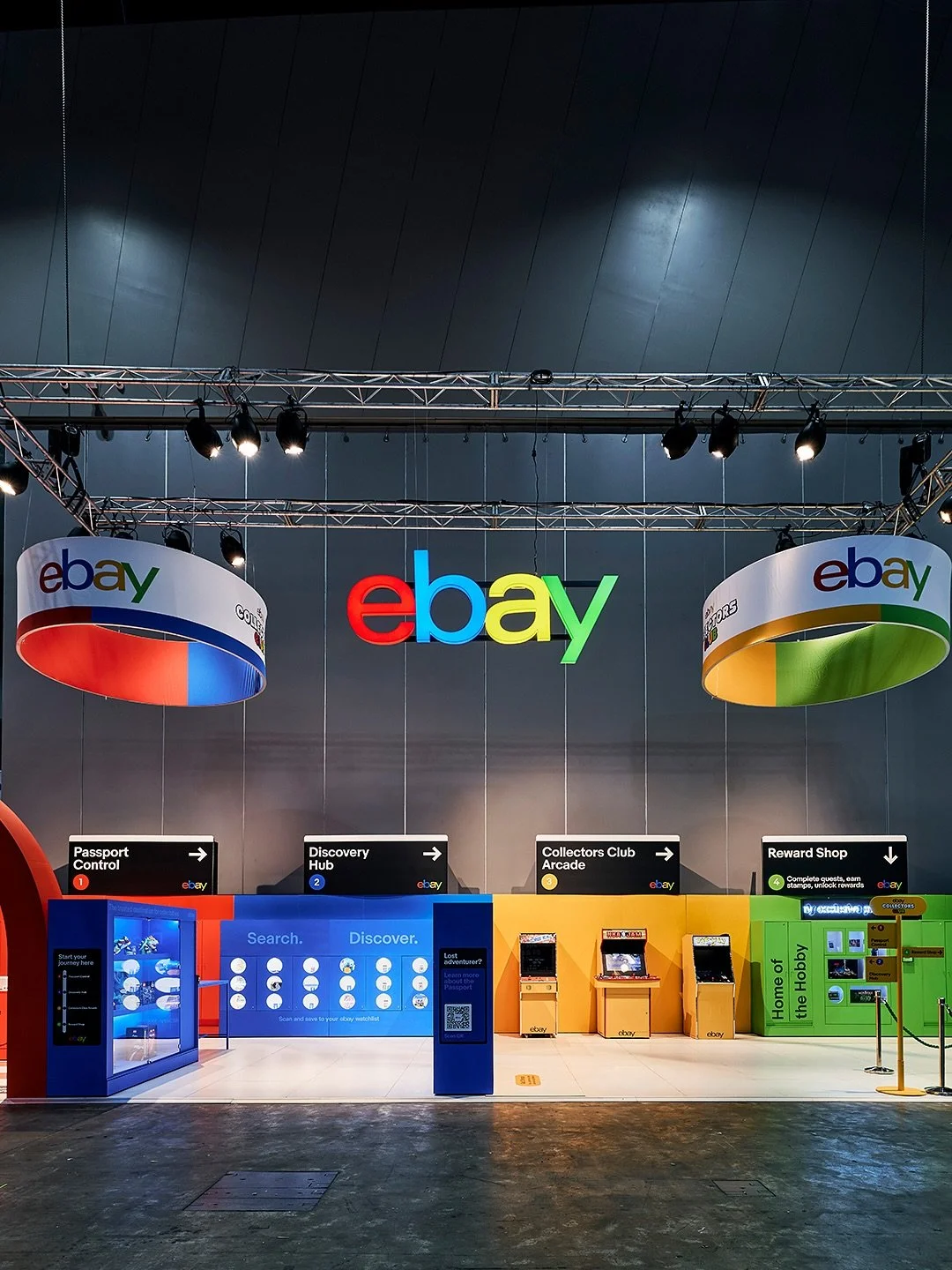 Ebay booth at a convention or event with colorful signage, arcade games, and information counters.