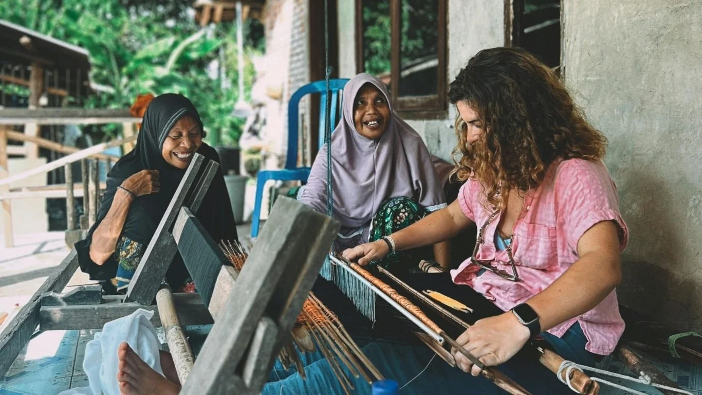 Traveller learning traditional weaving with local women in Lombok, reflecting the warm hospitality and genuine connections visitors remember long after their trip.