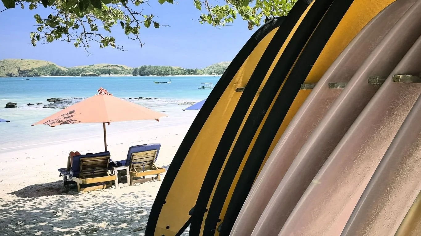 Surfboards lined up on the beach in Kuta Lombok, where many visitors discover a love for surfing after arriving on the island.