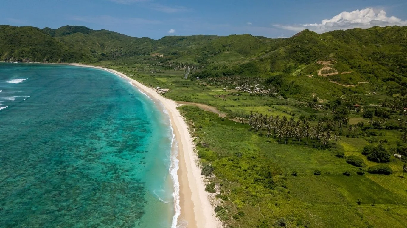 Aerial view of Tampah Beach featuring pristine white sand and turquoise water on Lombok's south coast.