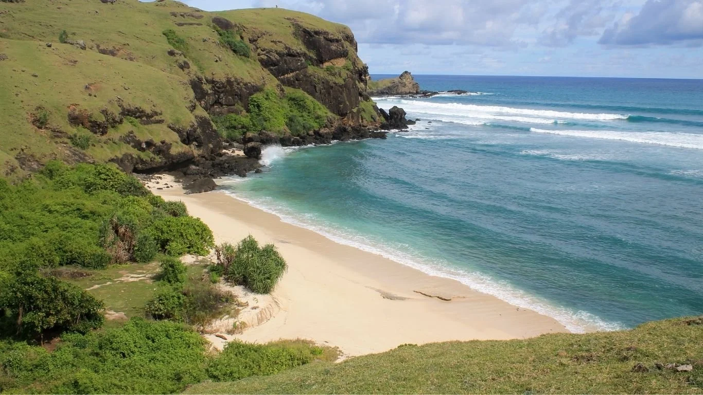 Secluded beach surrounded by cliffs in South Lombok, showing why many travellers discover their favourite beaches away from the island's most famous spots.