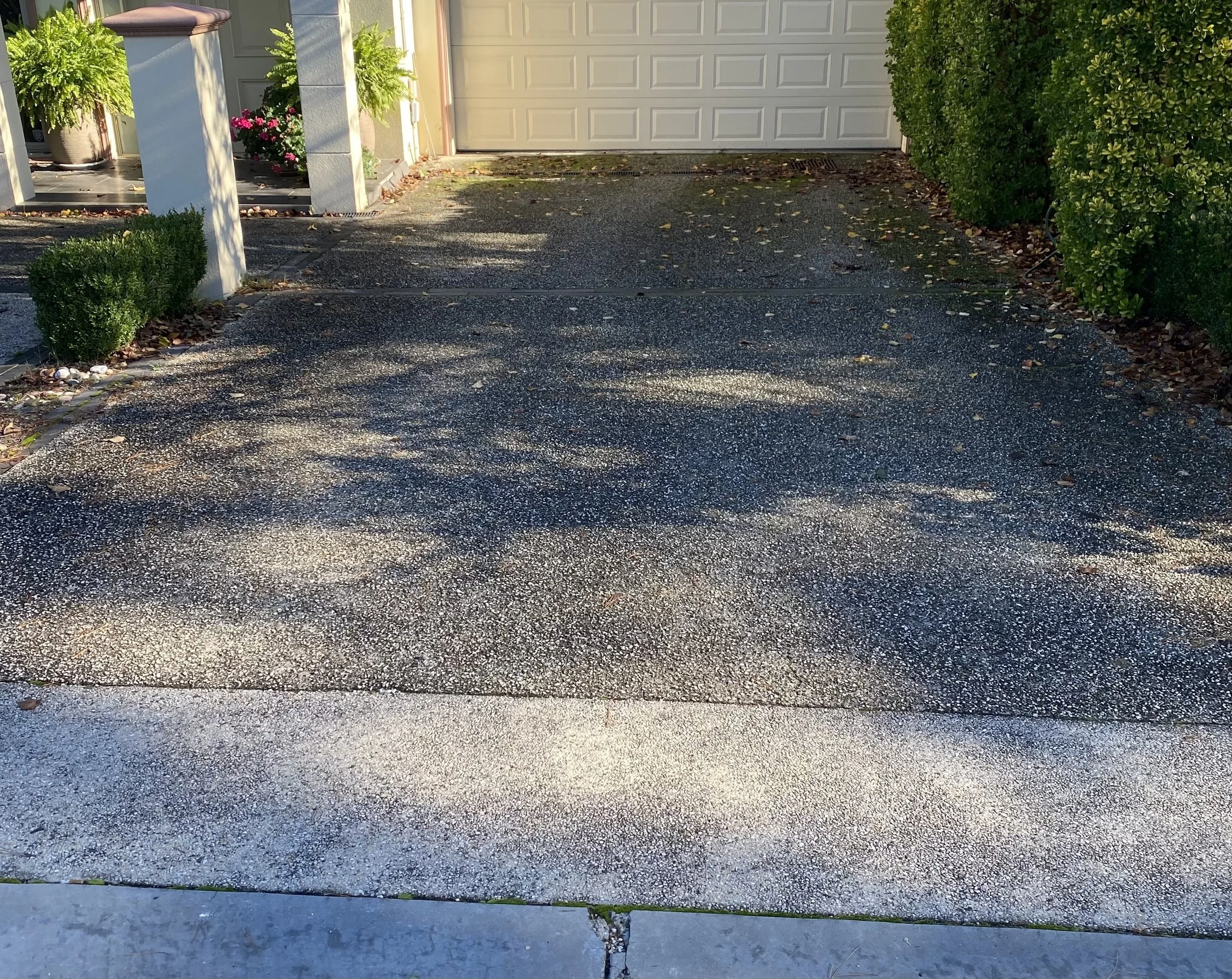 Exposed aggregate driveway in Templestowe before professional pressure cleaning, showing built-up dirt and surface staining.