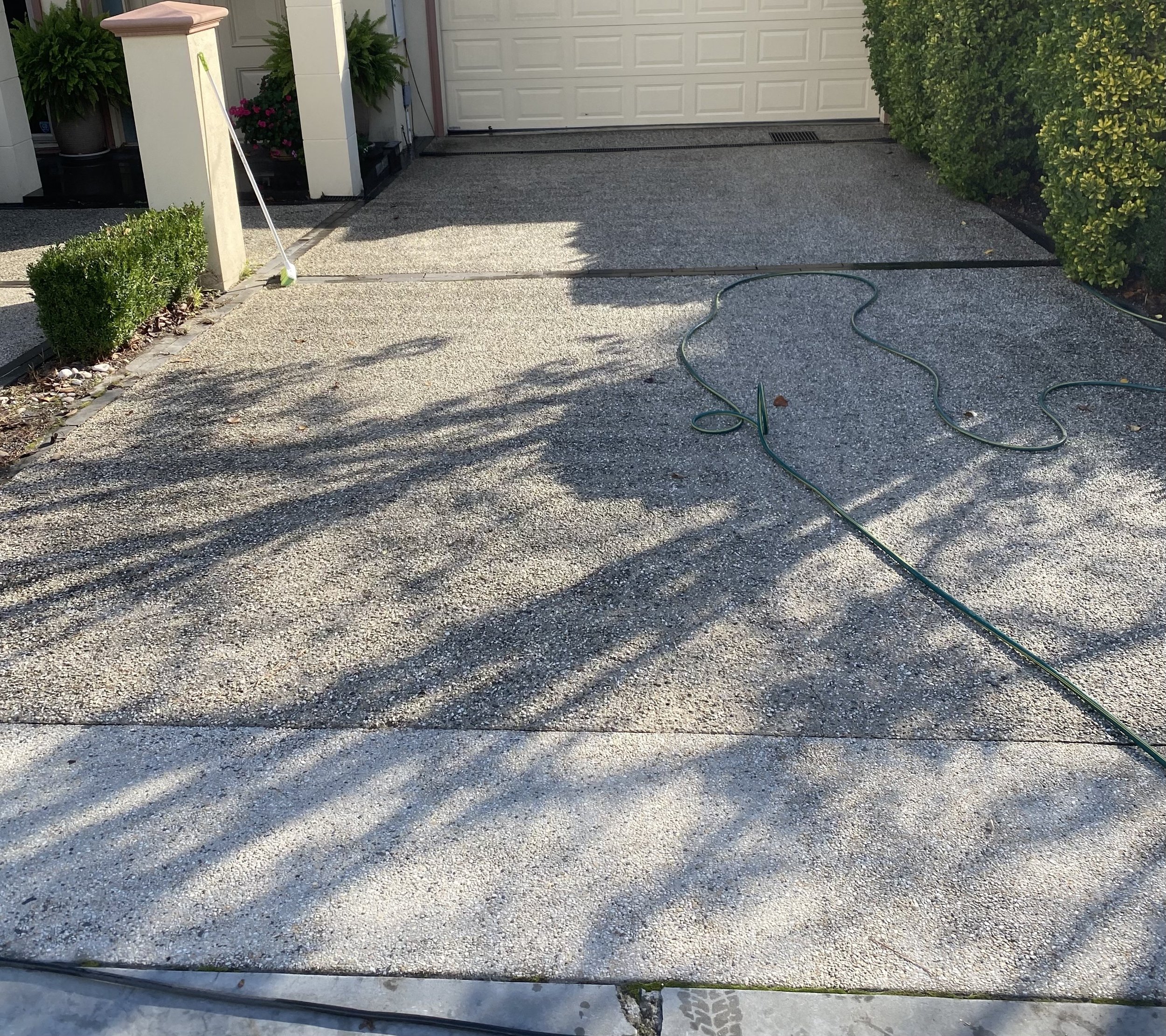 Freshly cleaned exposed aggregate driveway after professional pressure cleaning by Jet Power Pressure Washing.