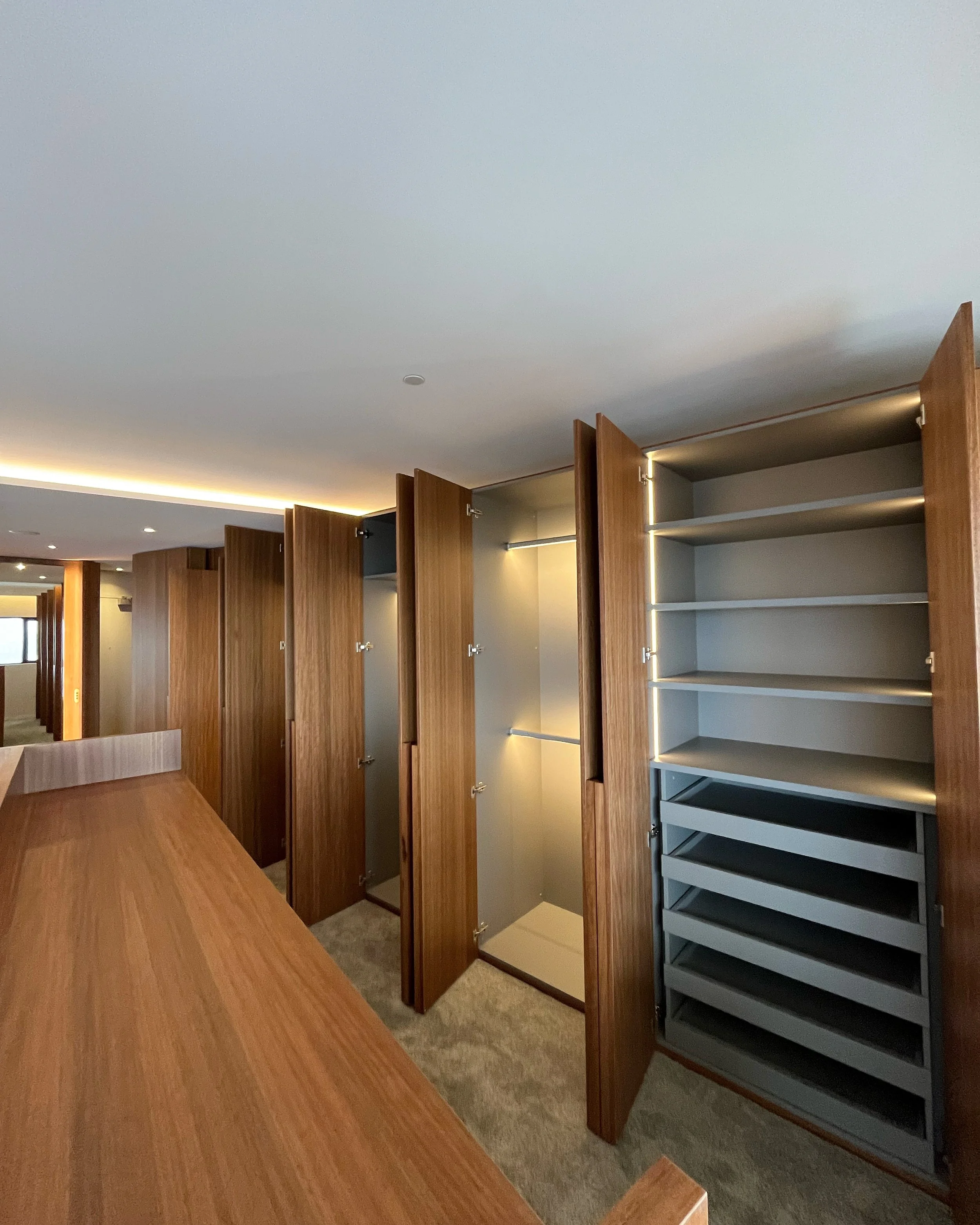 An empty wooden cabinet with multiple shelves in an office or conference room.