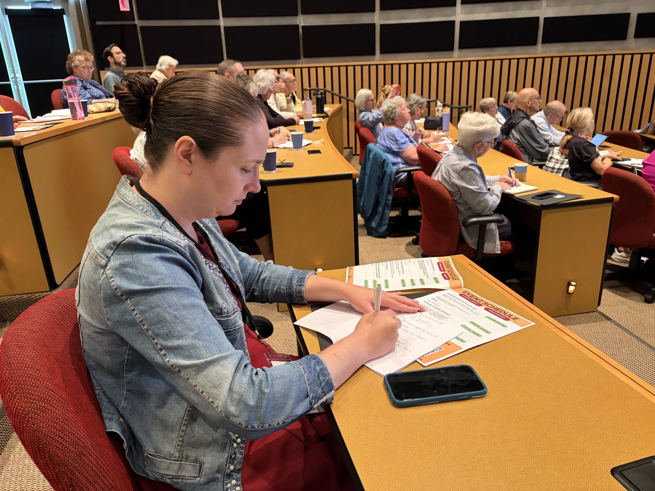 Tiffany Brault taking notes at the WISDOM Immigration Summit at Marian University