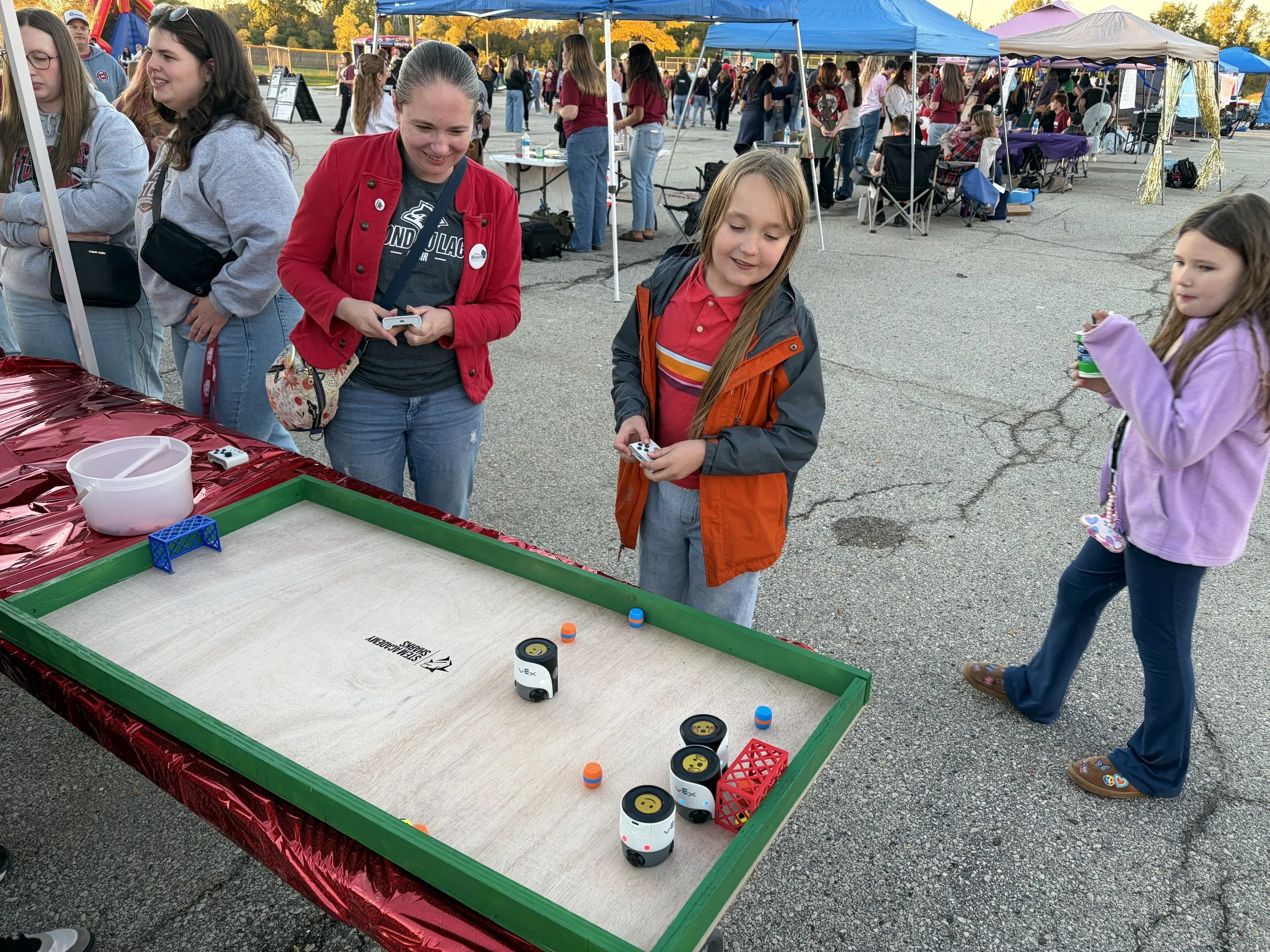 Tiffany Brault and her son trying out robotics at the Fond du Lac Homecoming Tailgate