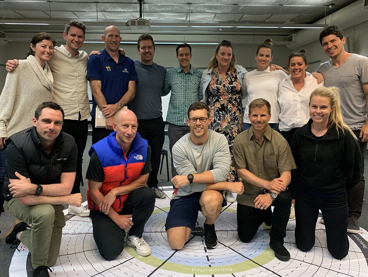 A group of professionals smile at the camera for a group photo after completing a Nobis team workshop.