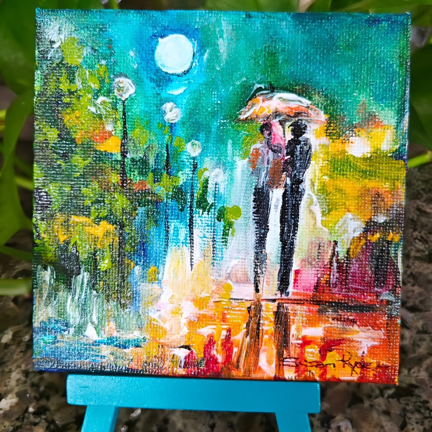 A colorful impressionist-style painting of two people holding an umbrella on a rainy day, with trees and a bright moon in the background.