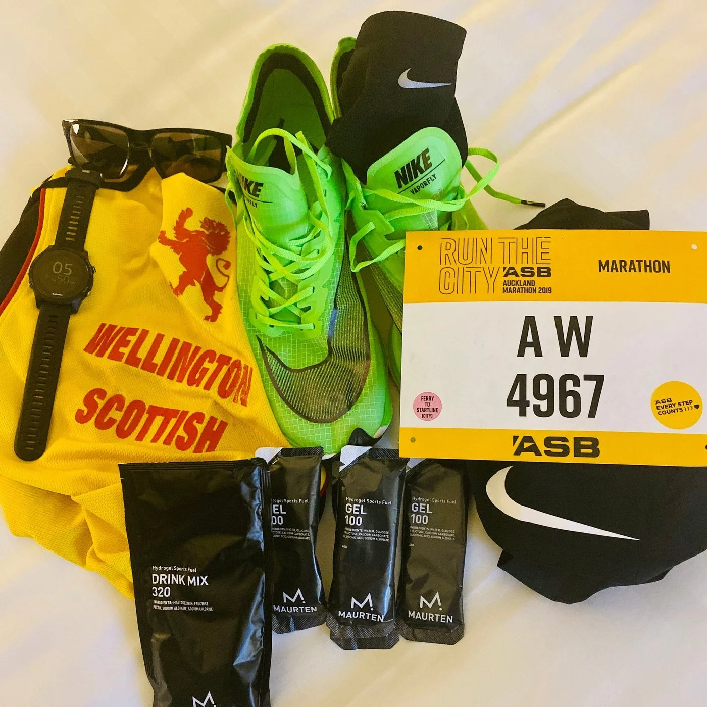 Race kit laid out for the 2019 Auckland Marathon: Nike Vaporfly shoes, Garmin watch, race bib 4967 and Maurten drink mix and gels