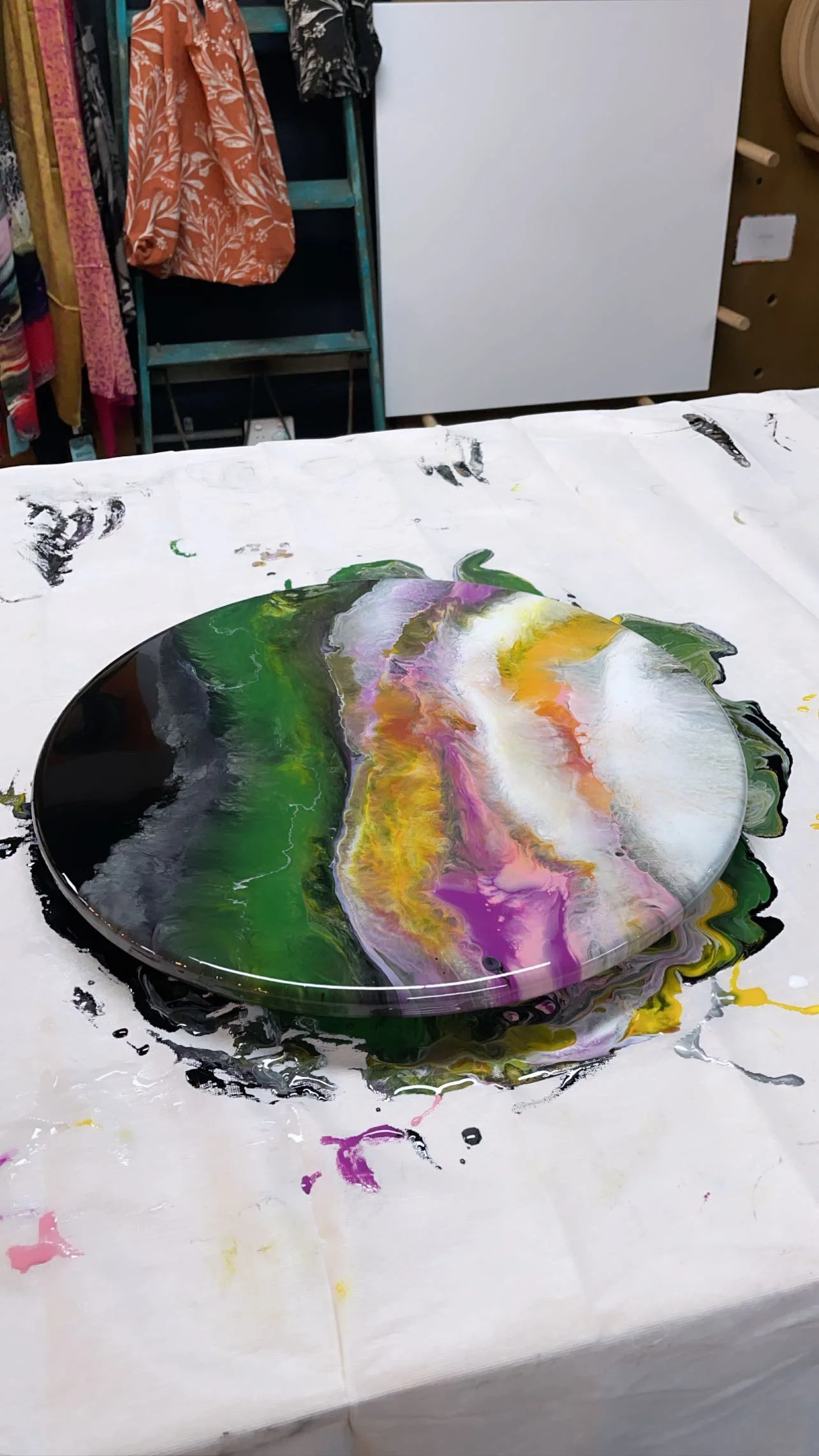 resin artwork with a mix of black and other additional colours on a work table