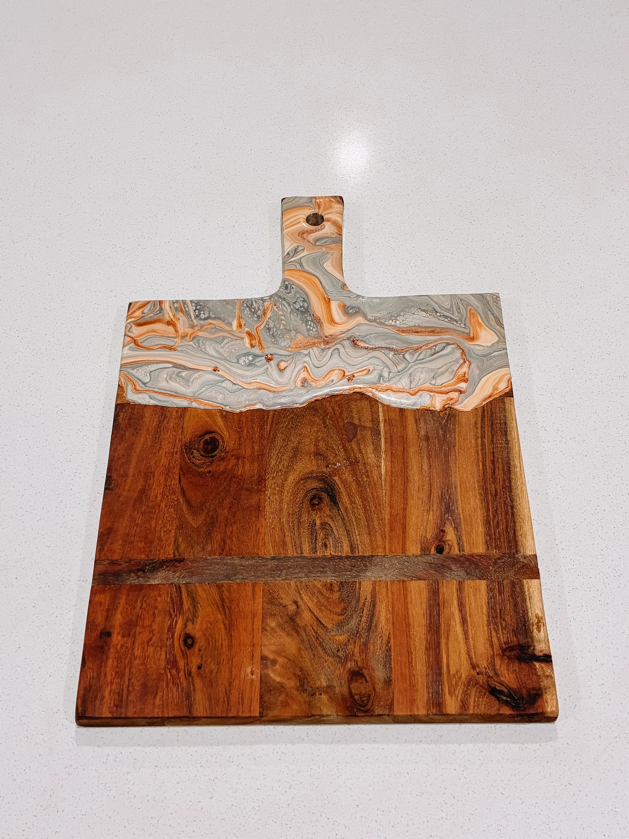 Wooden chopping board with decorative resin on the handle