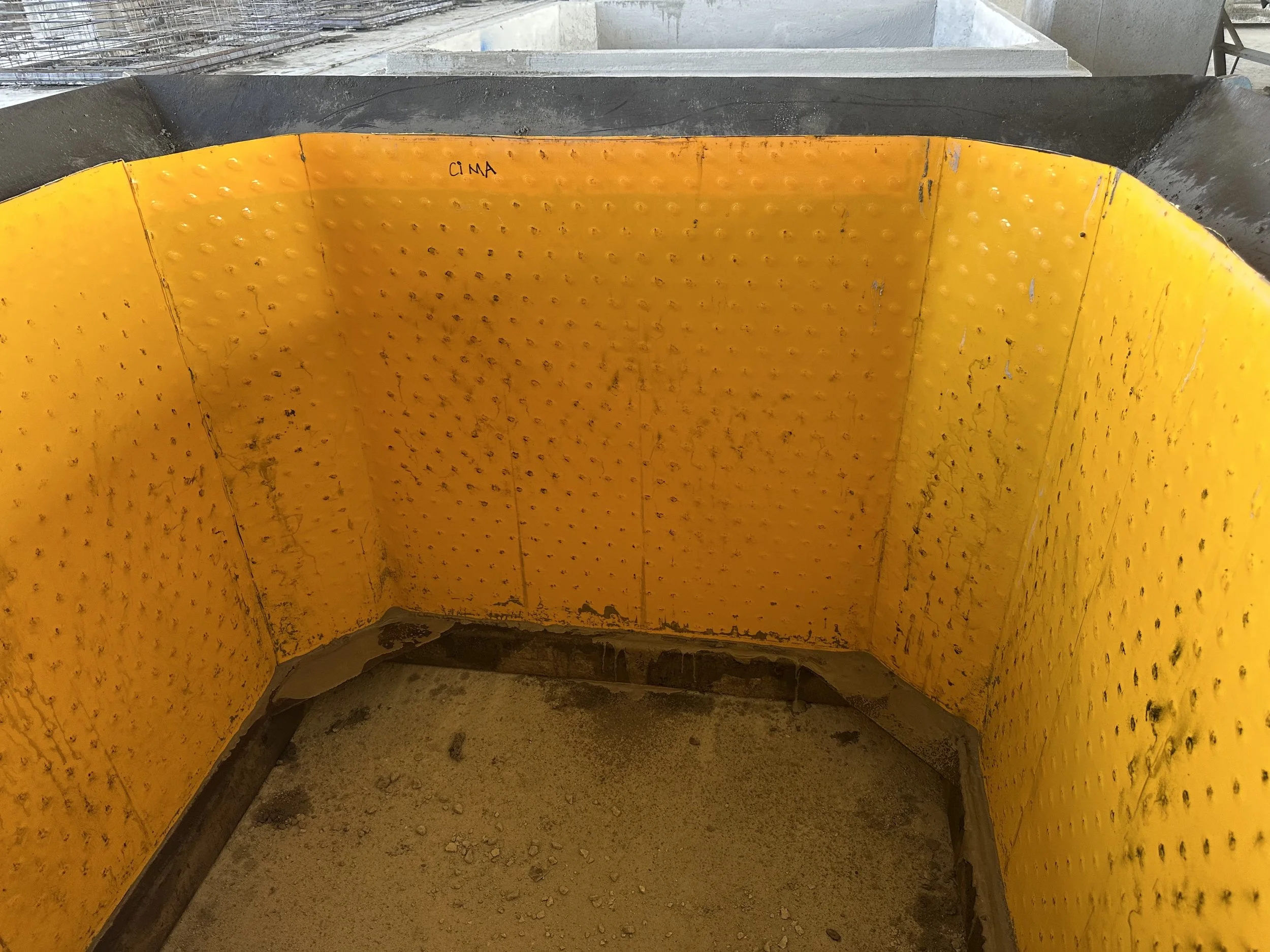 Rectangular concrete chamber lined with yellow HDPE anchor knob sheet