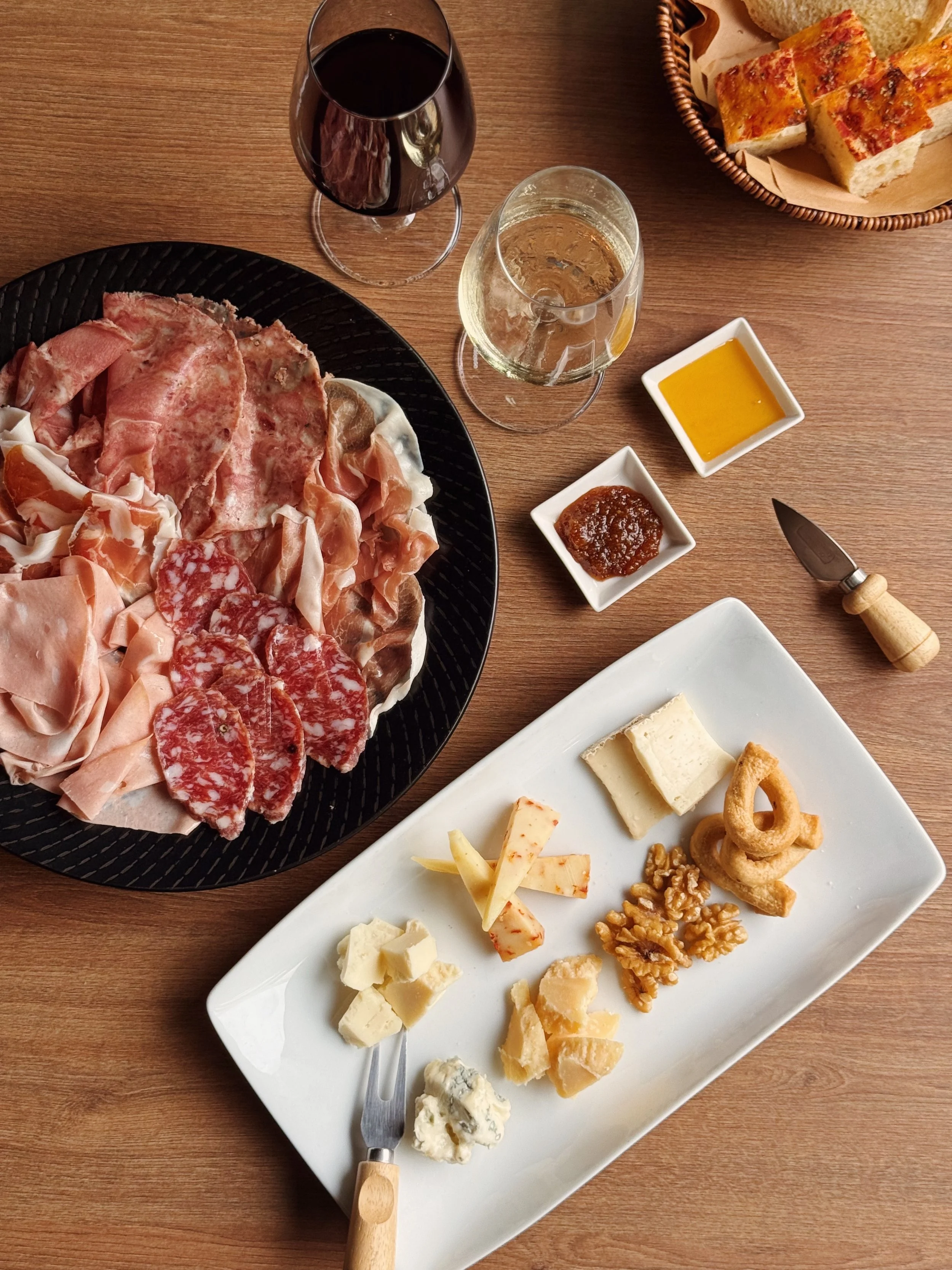 Italian cheese and charcuterie platter served with wine at Giando restaurant.