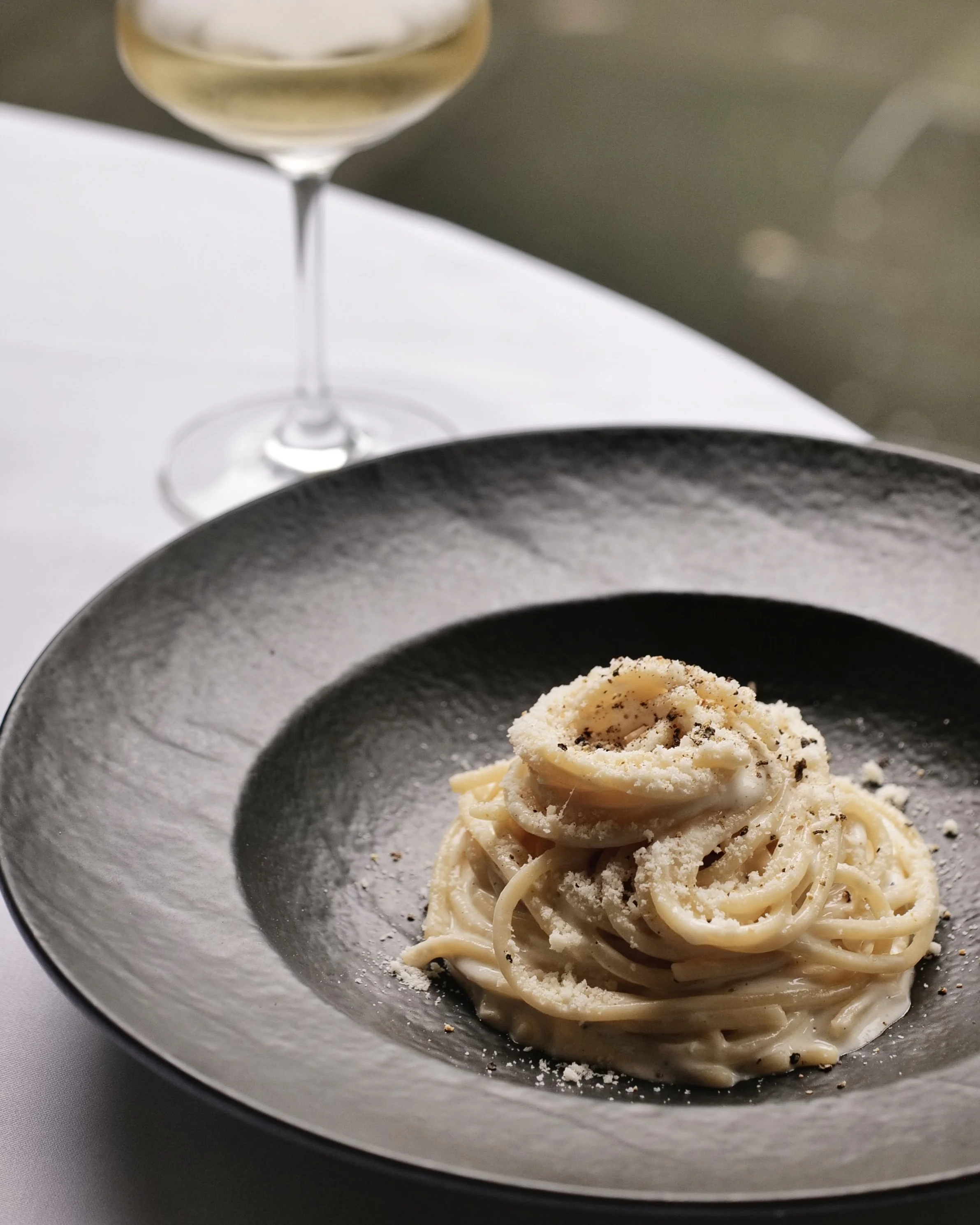 Authentic Italian spaghetti pasta dish served with white wine at Giando.
