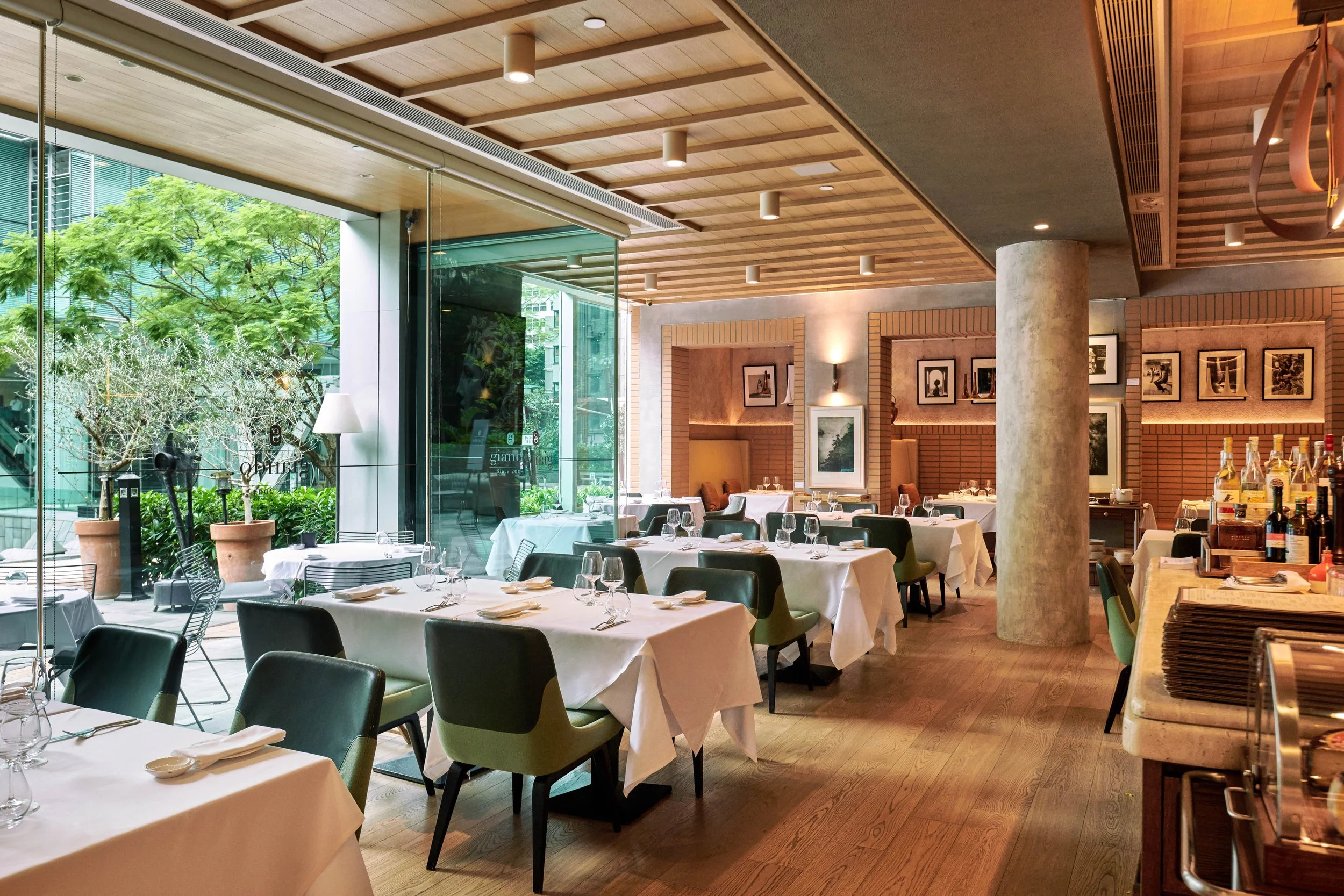 Upscale dining room with linen-draped tables and garden views at Giando.