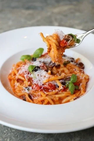 Classic Italian spaghetti pasta with tomato sauce, fresh basil, and cheese at Giando.