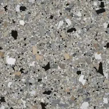 Close-up of speckled terrazzo flooring with black, white, and gray chips.