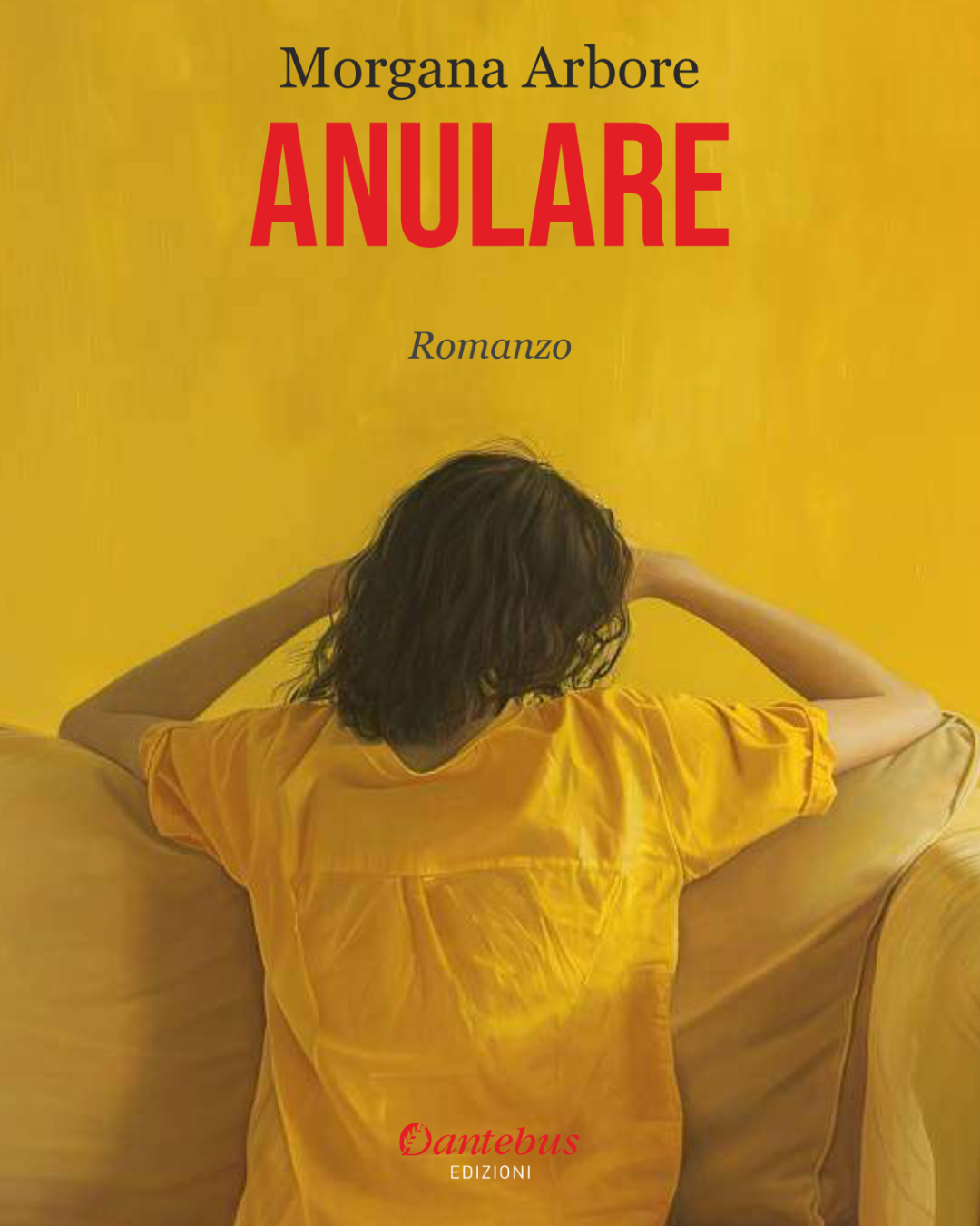Copertina di un libro con sfondo giallo e una donna seduta sulla schiena di un divano, con le mani dietro la testa e i capelli ricci, con titolo 'Anulare' di Morgana Arbore.