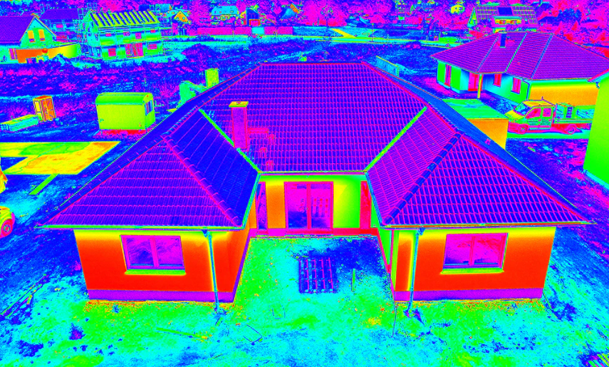 Thermal image of a house with a tiled roof and surrounding construction site.