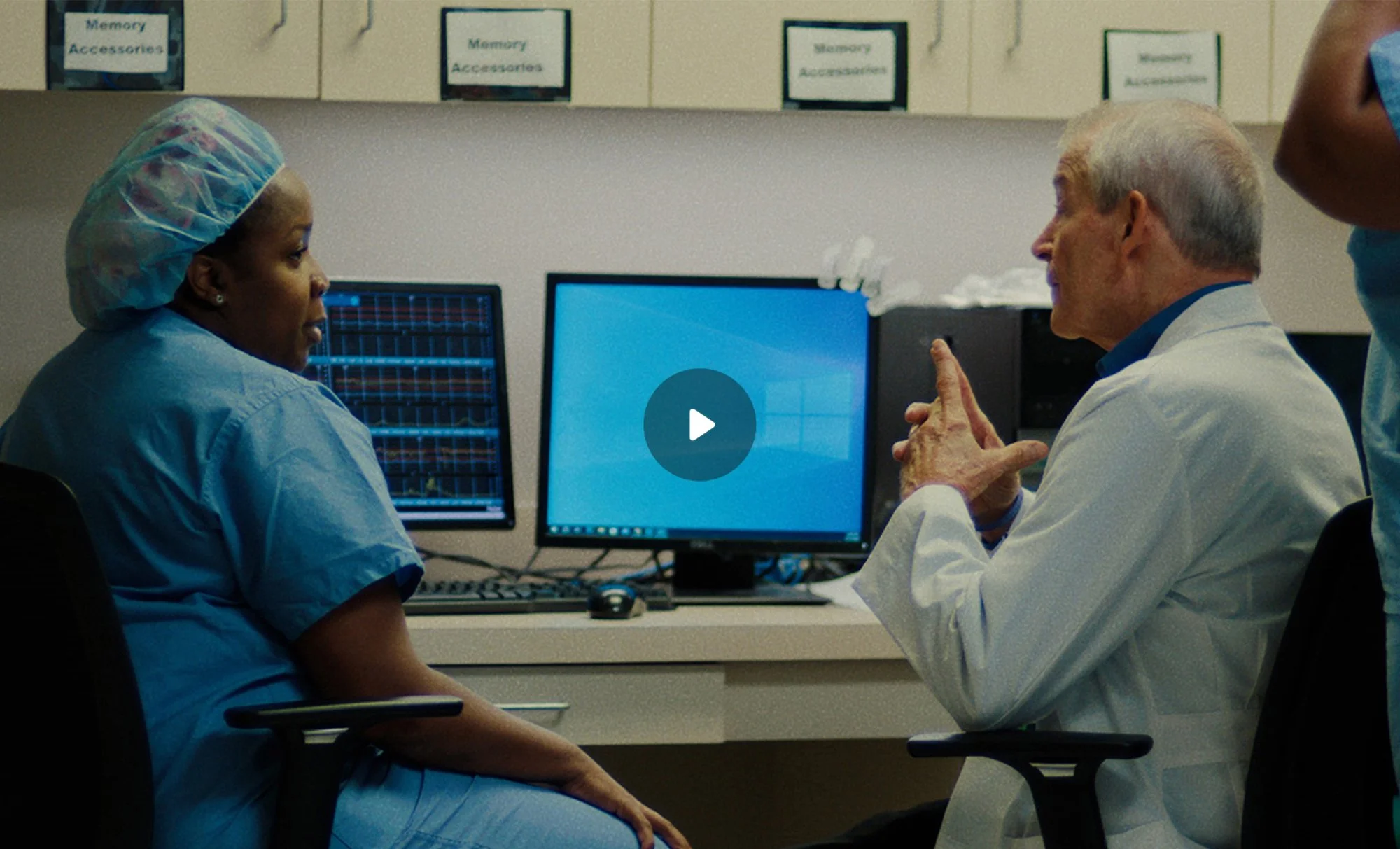 OB/GYN Dr. Sheena Favors in scrubs sitting with Dr. James Hotz at a medical workstation in Albany, Georgia, in a scene from the short film Doc Albany.