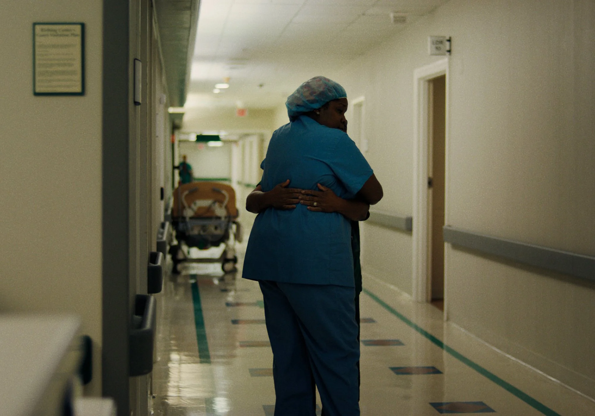 Healthcare worker embracing colleague in hospital hallway representing compassion in rural healthcare