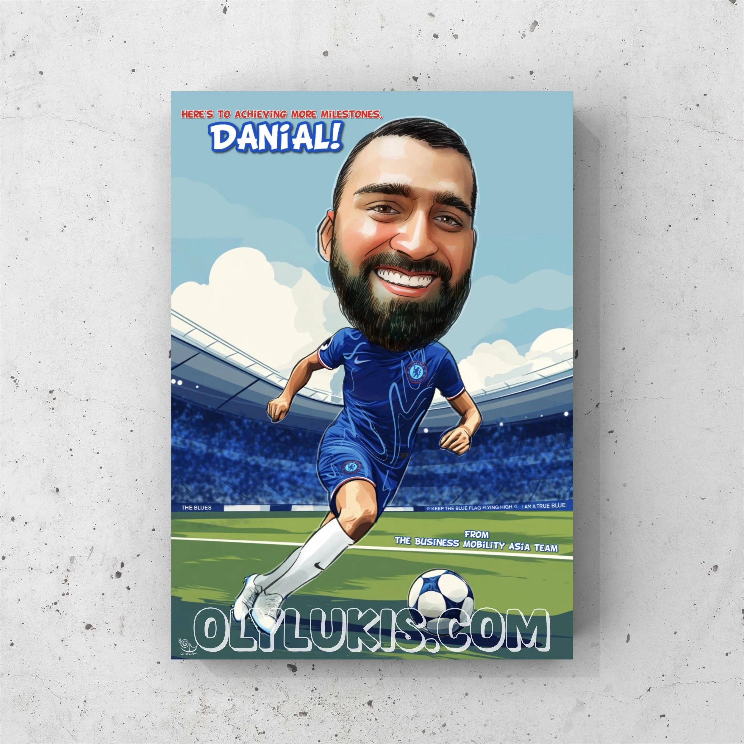 A caricature illustration of a man with dark hair and beard, wearing a blue Chelsea football jersey, kicking a soccer ball with a stadium in the background. The text says, "Here’s to achieving more milestones, Danial!" and references a business mobil