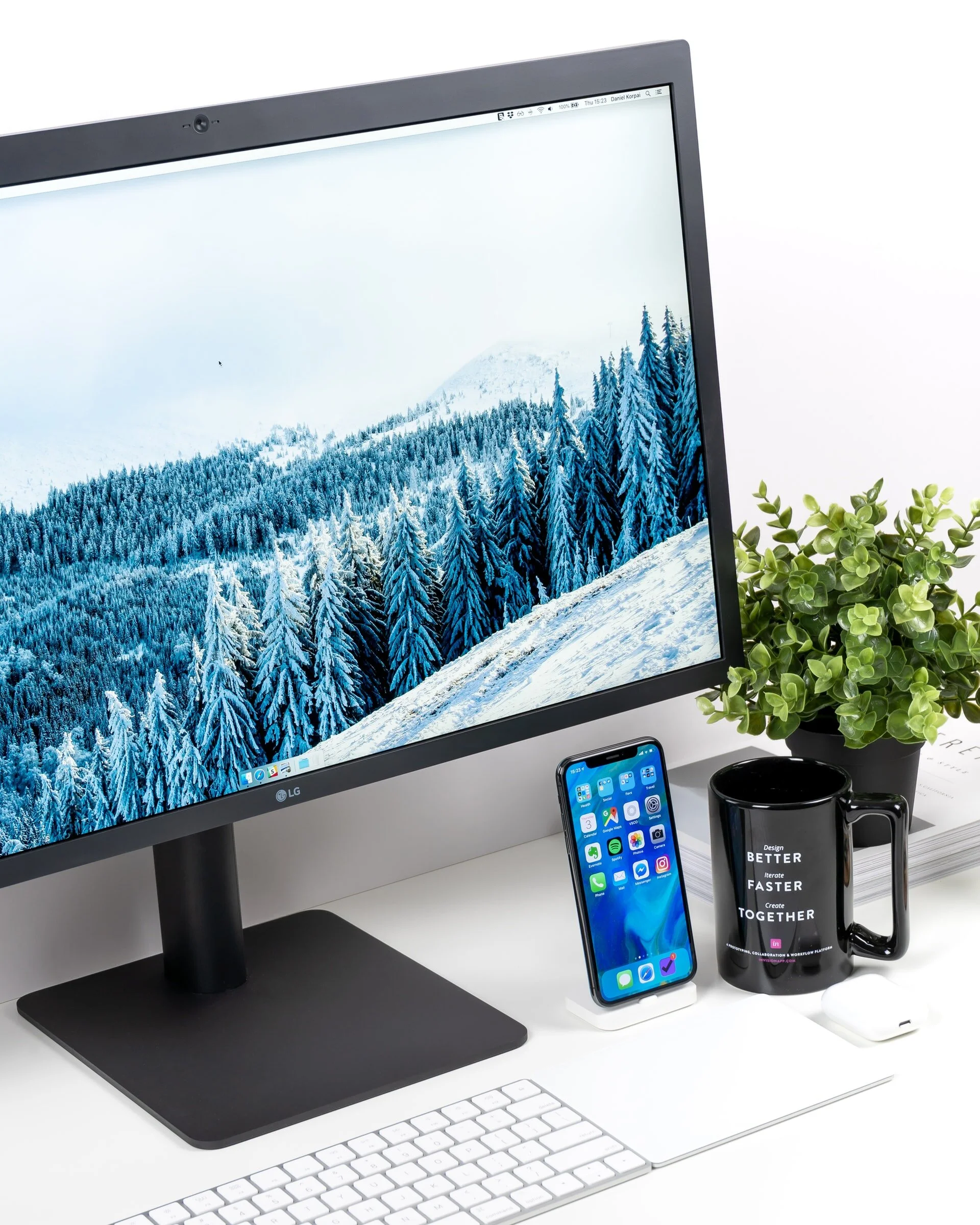 Computer, phone, mug and plants on a surface