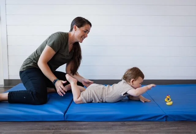 Jordan Greiner, DPT assisting a boy with a genetic disorder to get into hands and knees and functional positions and crawl
