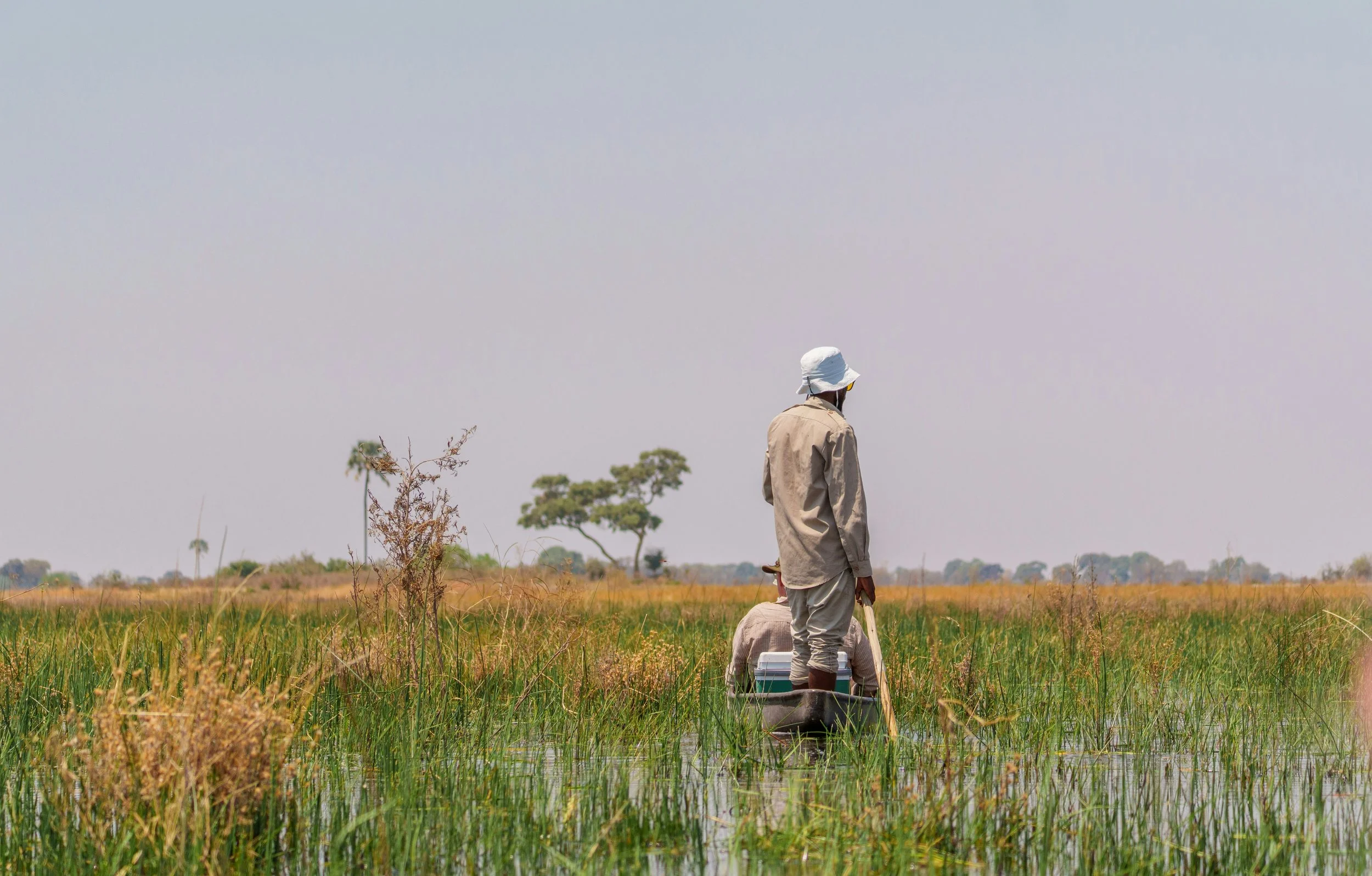 Hugo Morrissey, founder, and his partner on a Mokoro boat going along the Okavango Delta in Botswana.