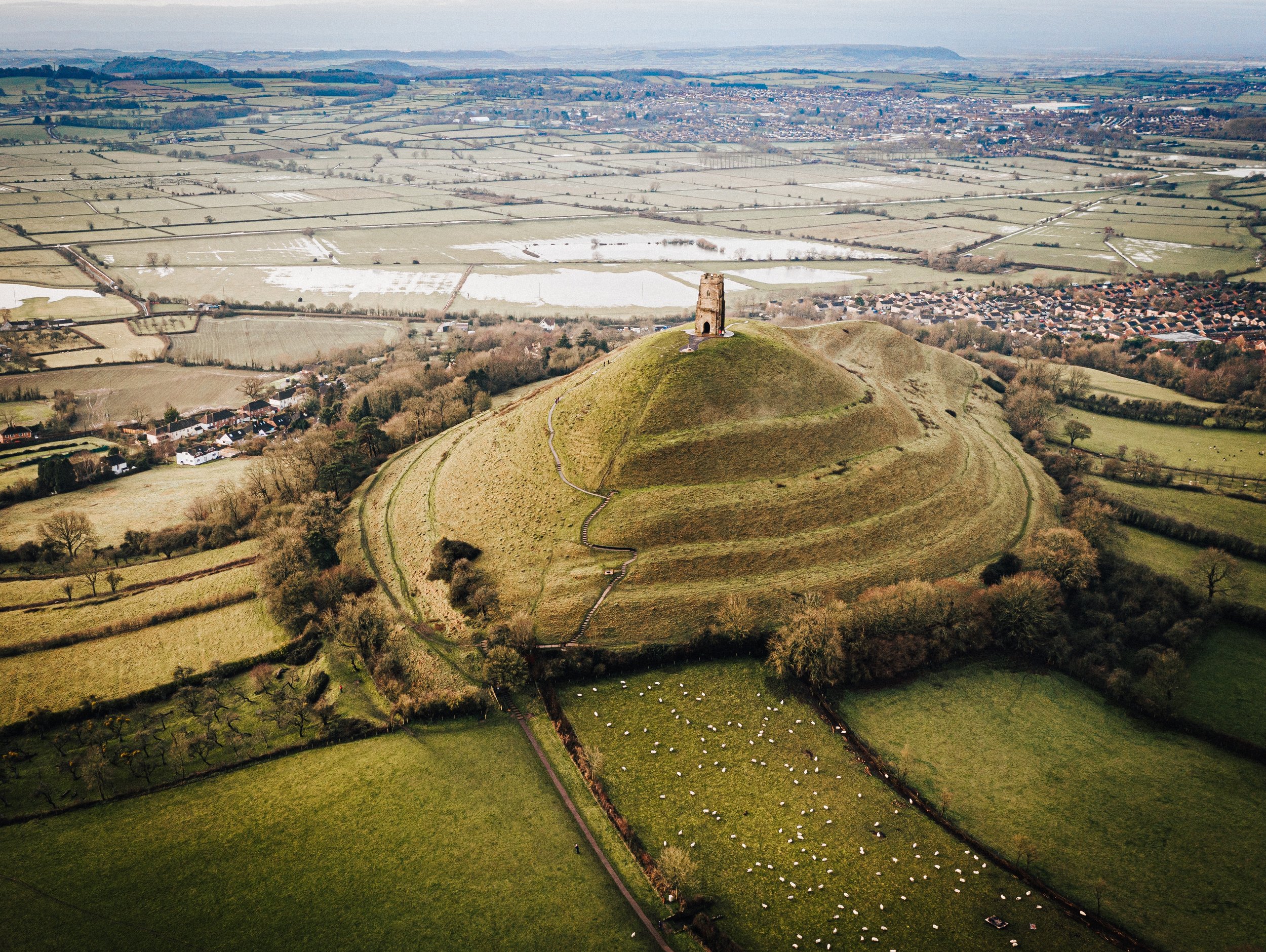 aerial-shot-old-castle-top-grass-covered-hill-middle-green-fields.jpg