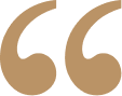 A close-up of quotation marks in a light, neutral background.