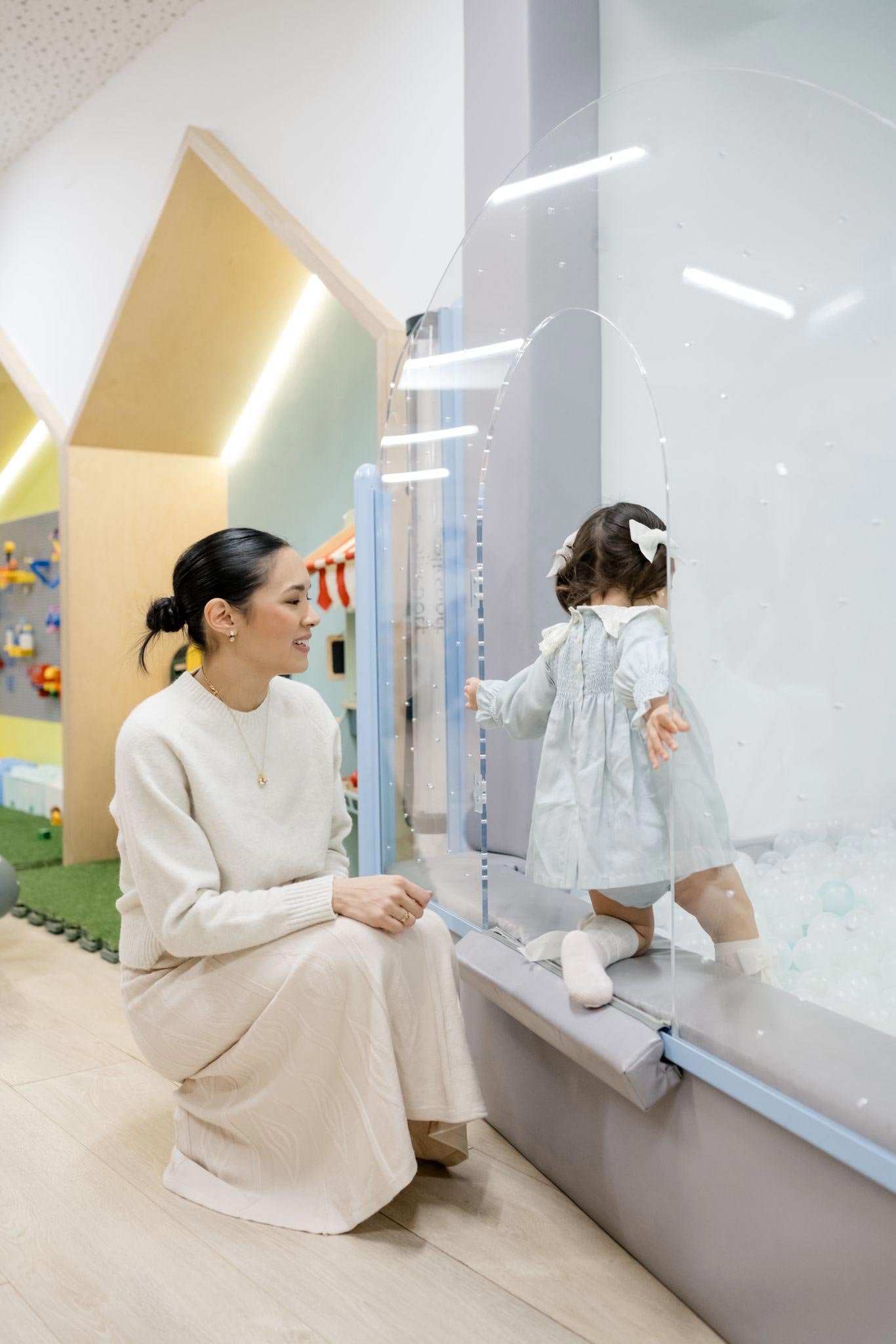 Adulto y niña explorando una actividad en Columpio Playground, espacio familiar para juego libre y actividades infantiles en Madrid.