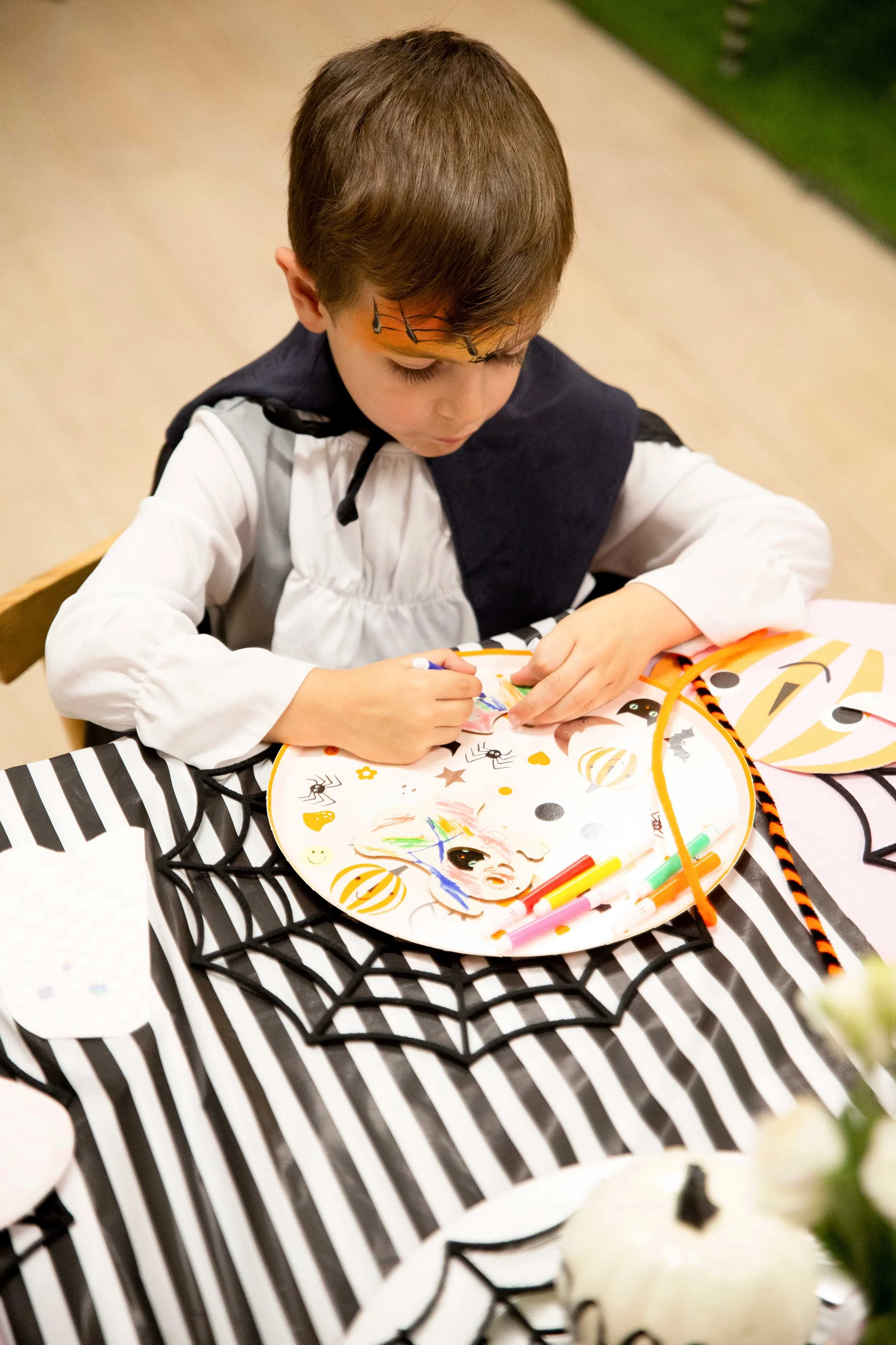 Niño decorando una calabaza durante una actividad de Halloween en Columpio Playground, espacio infantil creativo en Chamartín.