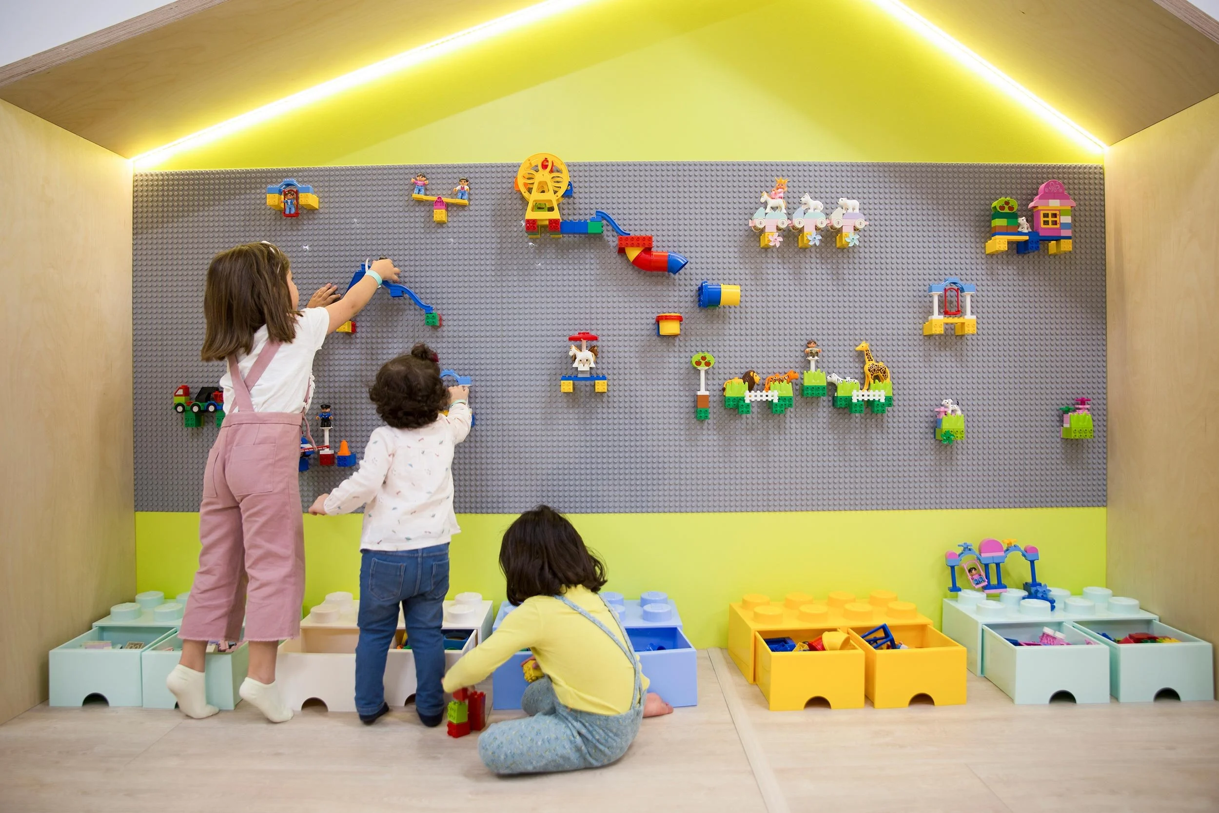 Niños jugando con bloques de construcción en Columpio Playground, espacio infantil para juego libre y actividades familiares en Madrid.