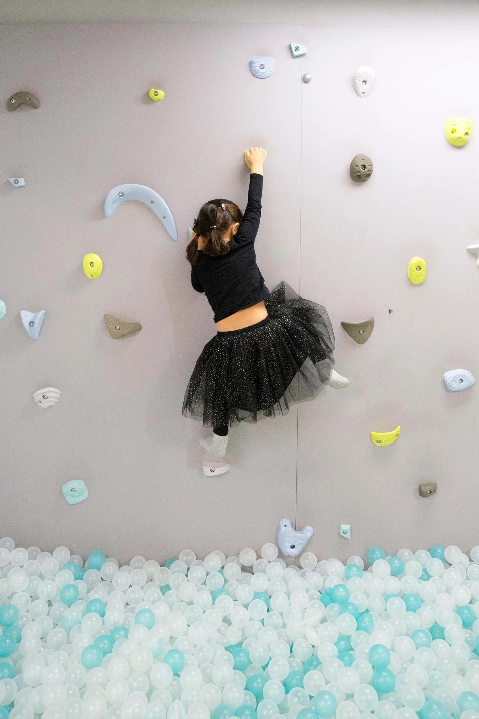 Niña jugando en el rocódromo de Columpio Playground, playground infantil en Madrid para juego libre y cumpleaños.
