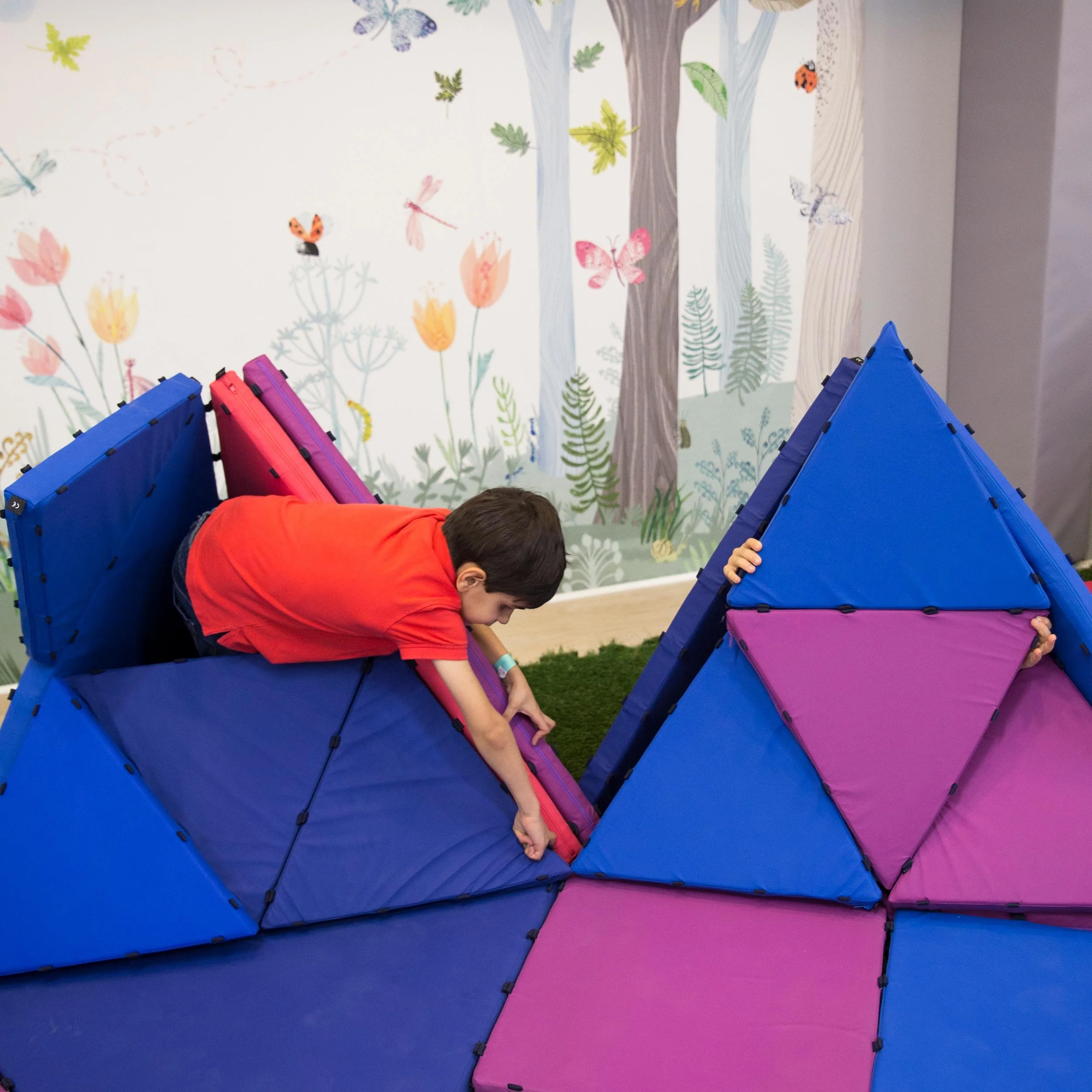 Niño gateando en una estructura de juego en Columpio Playground, playground infantil en Madrid para niños pequeños.